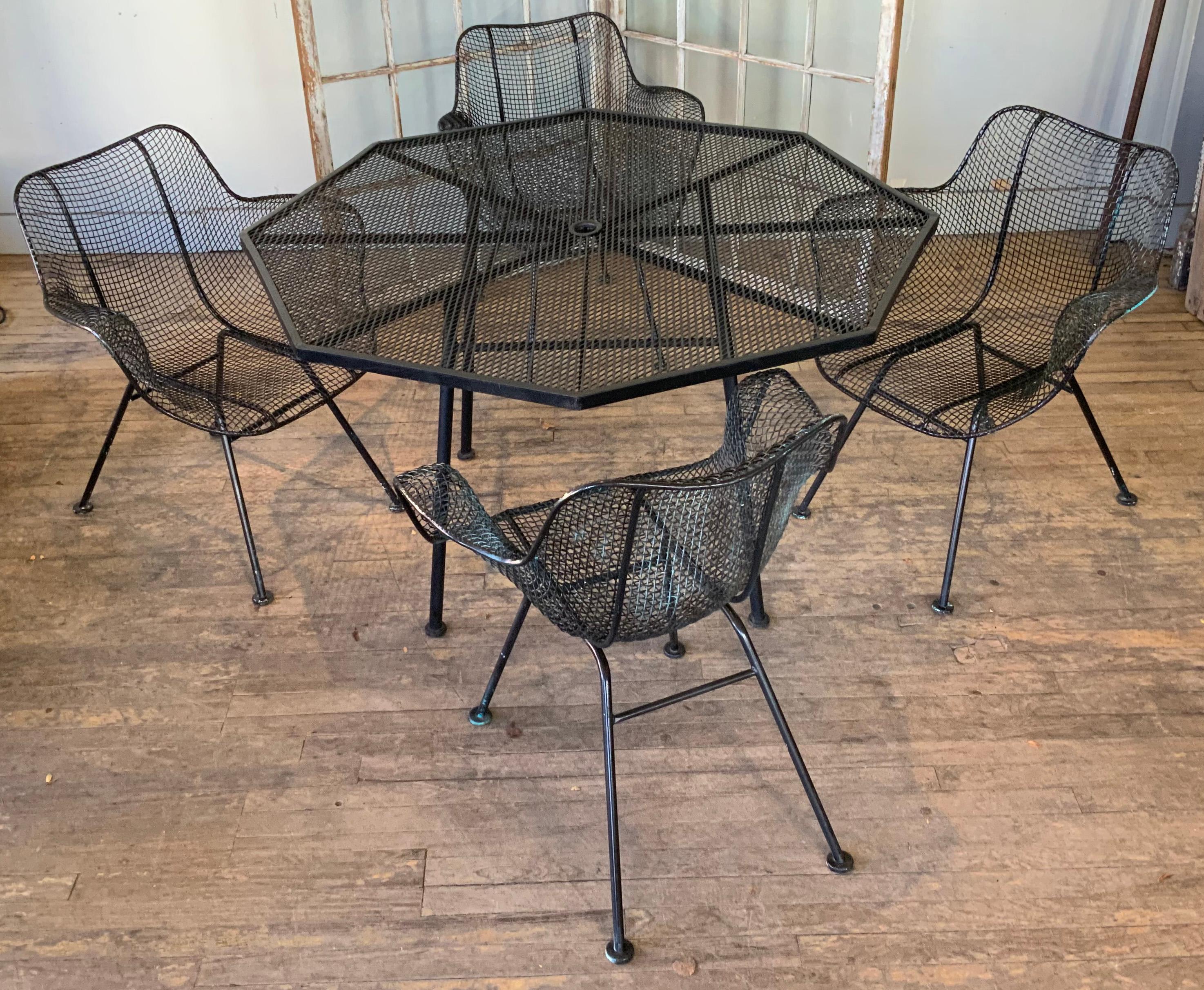 a beautiful vintage 1950's Woodard Sculptura wrought iron dining set. This set has the rare Octagon dining table, and four of the Sculptura armchairs. wonderful scale and details. the finish is satin black, which looks to have been done over an old