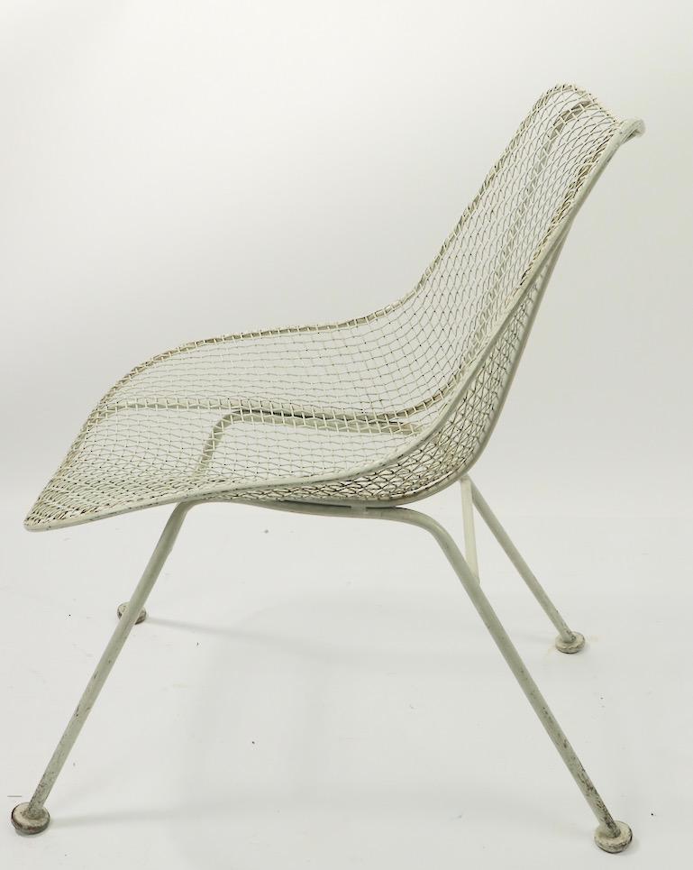 Slick midcentury side, or dining chair by the Woodard Furniture Company. Woven wire seat and back on wrought iron base. No structural damage, bends breaks or repairs, cosmetic wear to paint finish normal and consistent with age. Originally designed