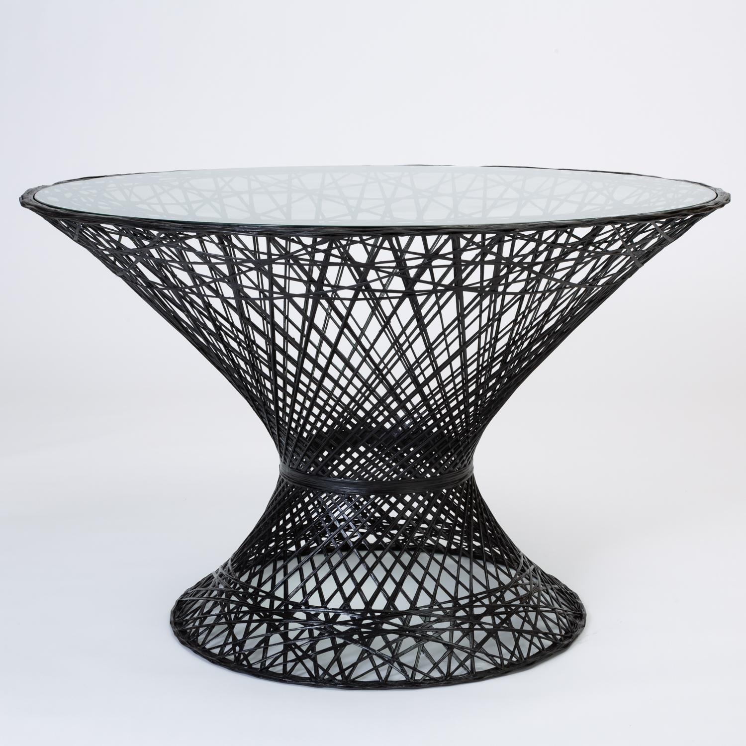 A dining table by Russell Woodard for his family company's popular line of spun fiberglass patio furniture. The design features an hourglass shape and round pedestal base. The frame is described by an intricate lattice of fiberglass spokes with a