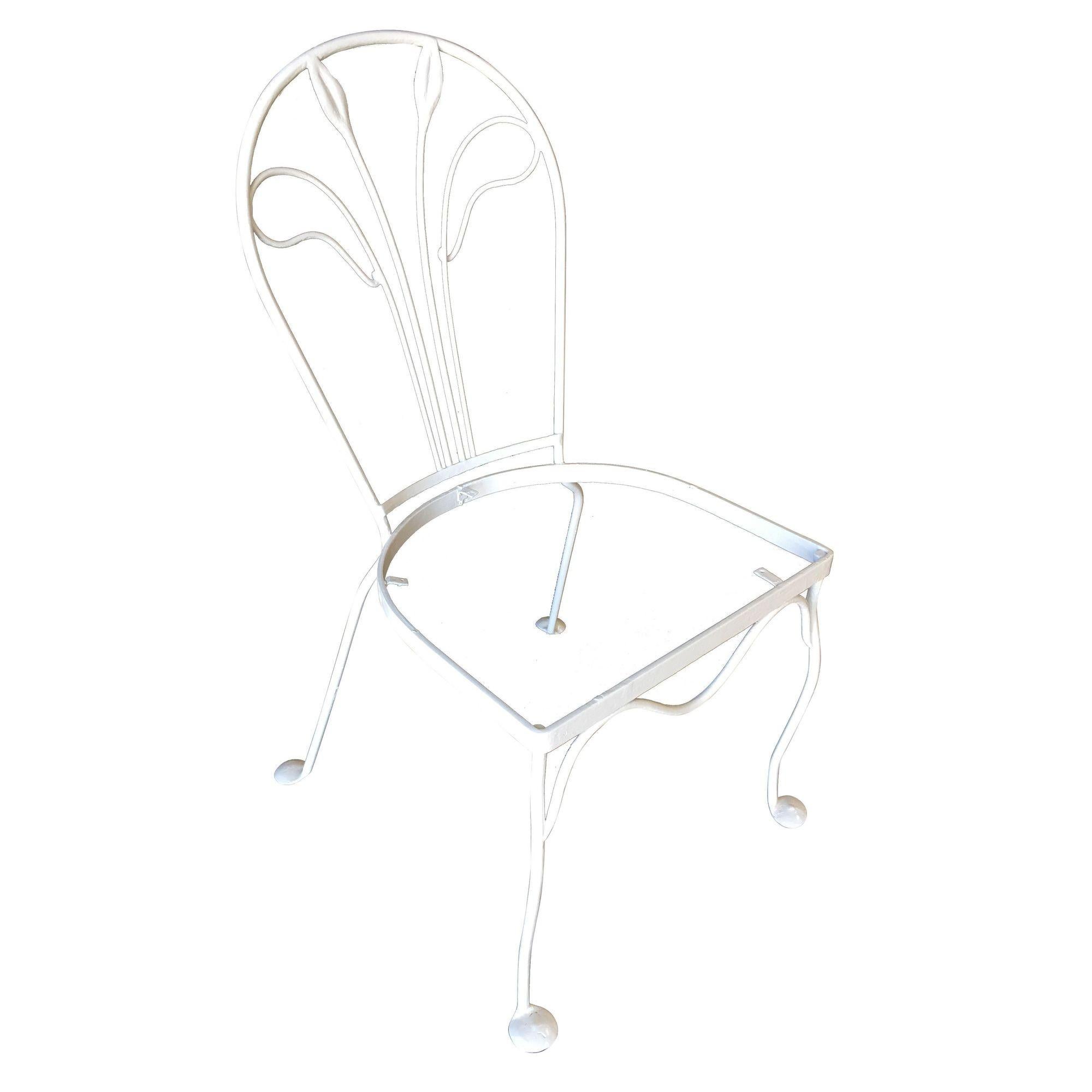 A set of four Woodard rod iron outdoor/patio chair with a distinct tropical leaf backrest. This chair is constructed with solid core iron rods and is finished in your choice of a pure white or black finish with padded seats. All outdoor furniture