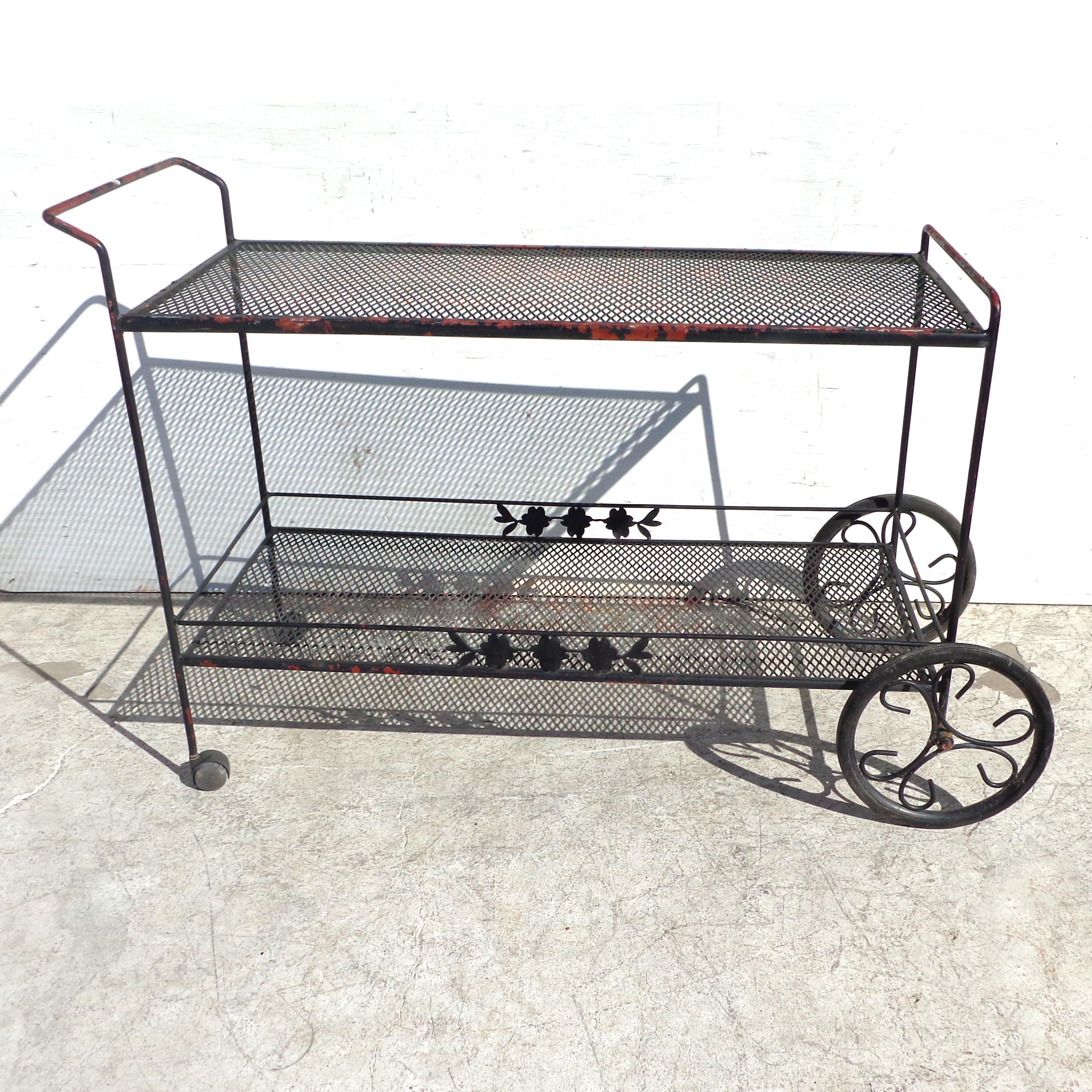 Woodard style wrought iron bar serving cart
 
2 tier mid-century metal bar cart by Woodard.
Wheels for mobility.
Measures: 48