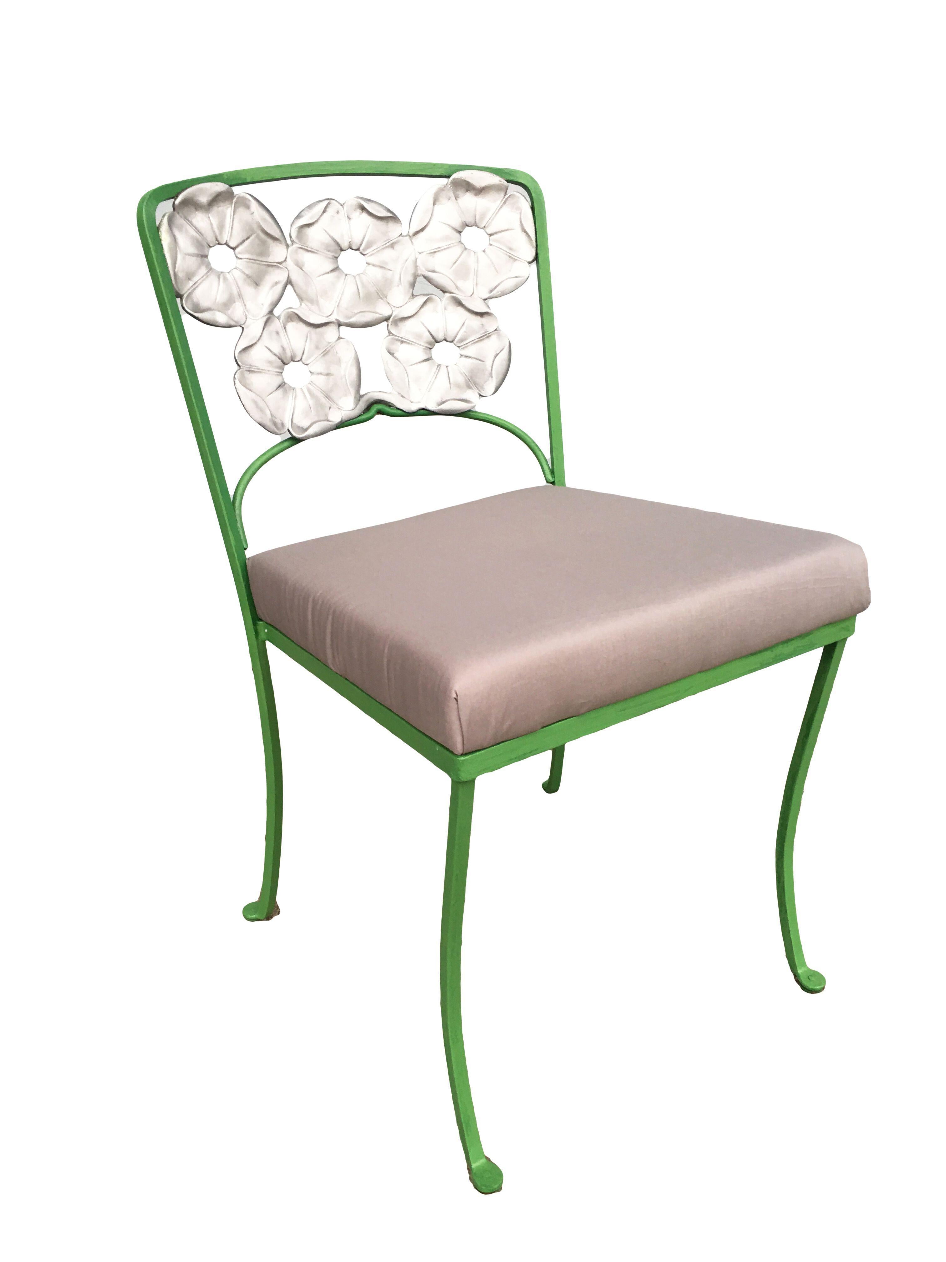 Woodard wrought iron outdoor/patio chair with a distinct silver-painted floral pattern backrest. This chair is constructed with solid core iron castings and is finished in green, circa 1950. All outdoor furniture can be repainted in the color of the