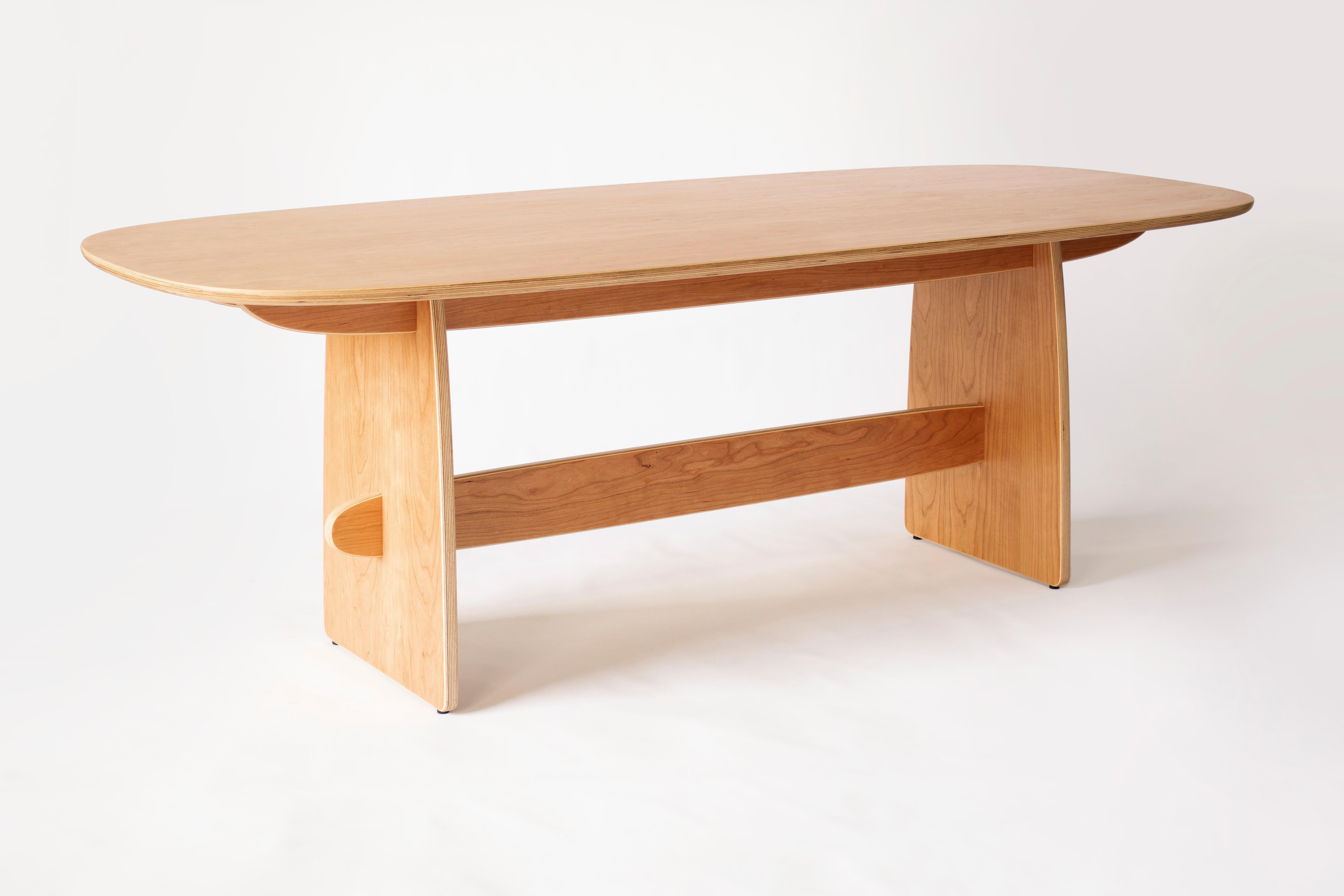 La table de salle à manger Woodbine est fabriquée à partir d'un épais contreplaqué de bois dur et d'un placage de cerisier avec une finition à l'huile frottée à la main. La base ludique apporte une touche lumineuse et joyeuse à n'importe quel
