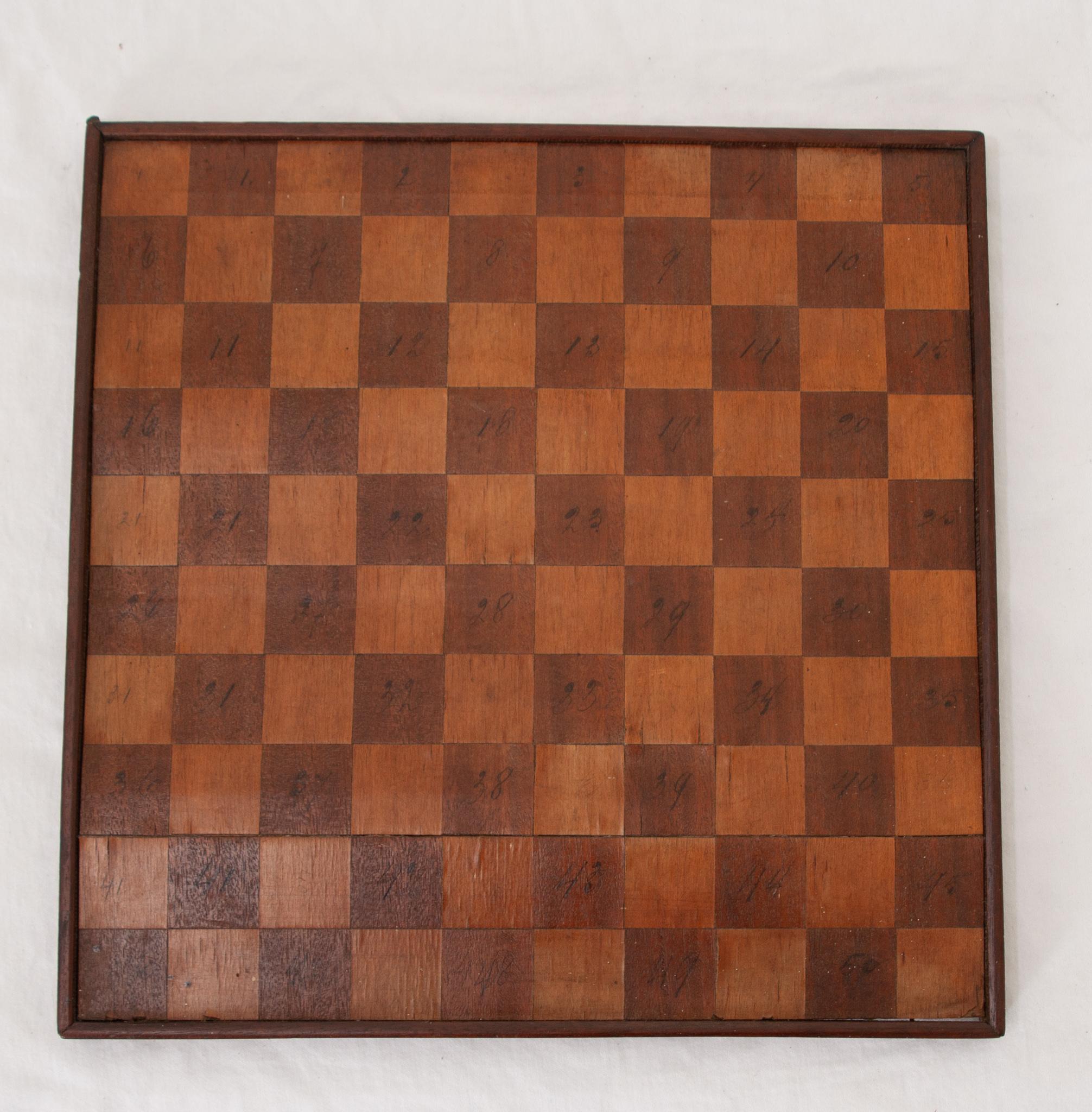 A vintage checkerboard made of alternating stained pieces of fruitwood veneer. This board has a wonderful patina and is an attractive game board that could be kept out at all times. Perfect for your home or as a gift. Be sure to view the detailed
