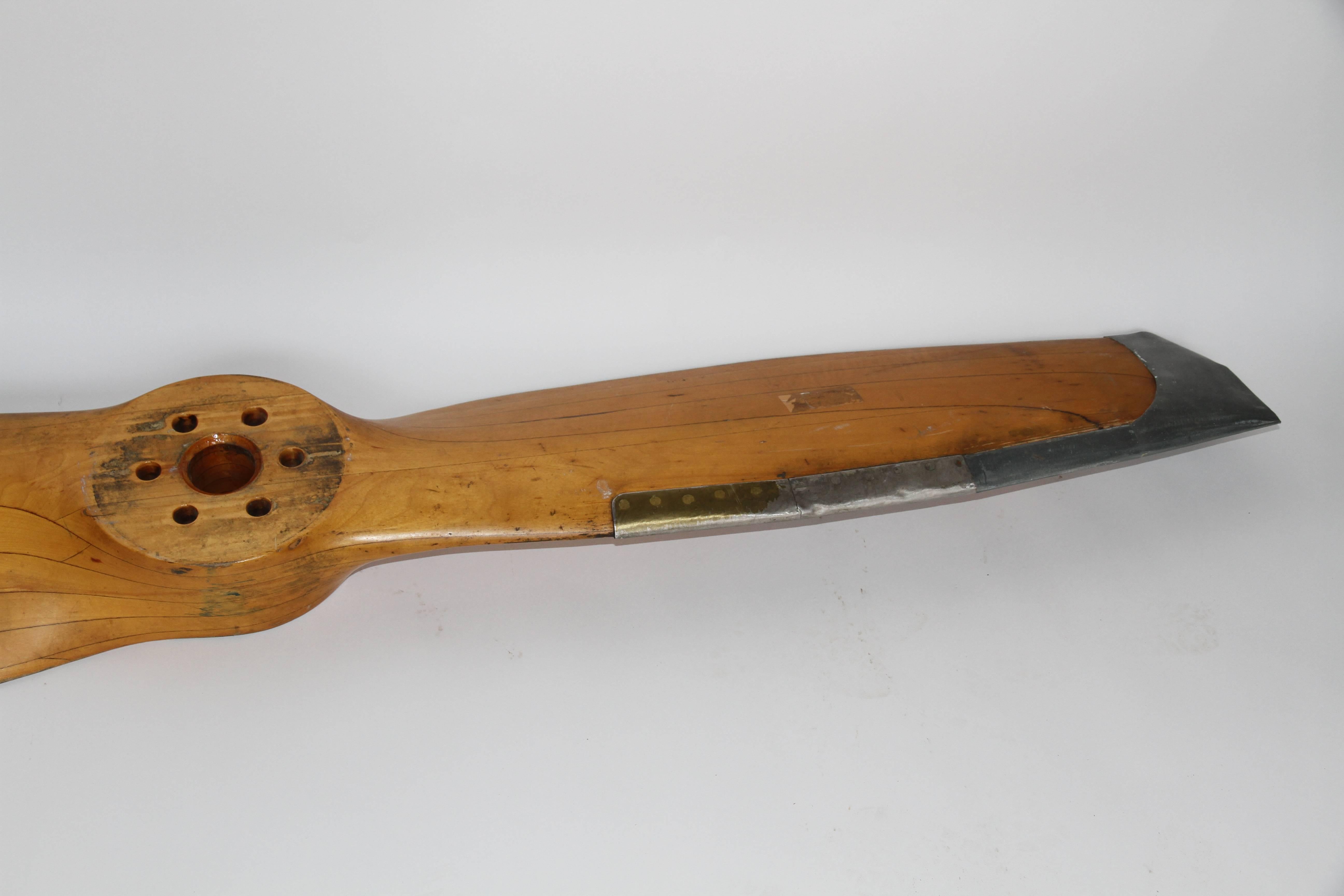 20th century hardwood two-blade metal tipped propeller stamped 78LXL50 5613. This propeller was made from solid wood planes sculpted and glued together. The blades are edged with metal to protect the propeller from wind blown objects.