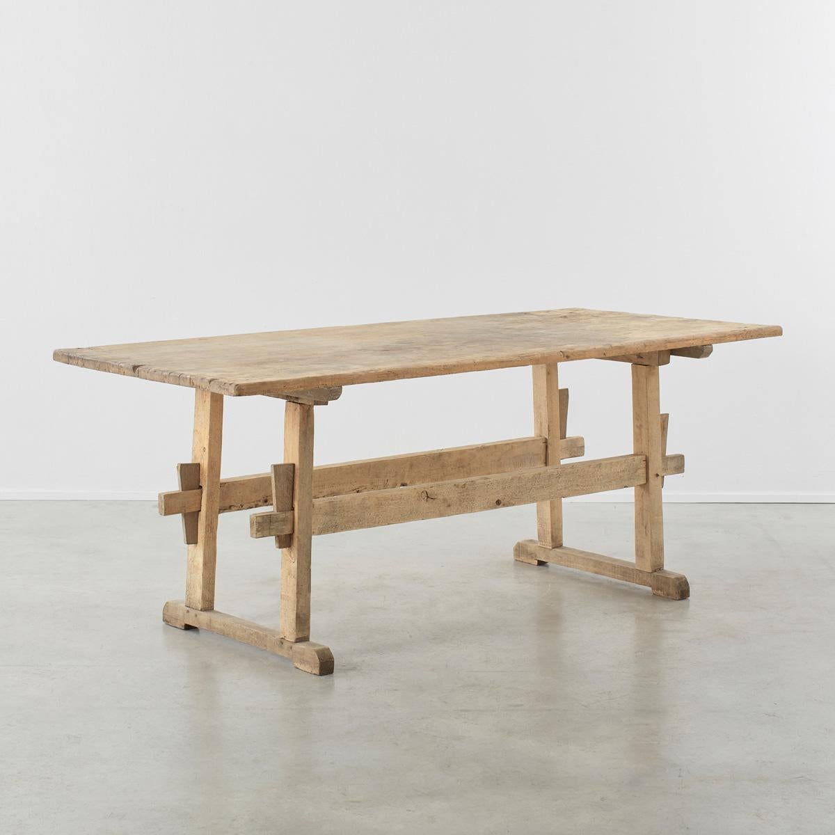 A sincere and elegant pine dining table from the Alps with natural sun-bleached patination which could easily seat six people. Its delightfully rustic character is enhanced by exposed loose-wedged mortise and tenon joints on the legs and an unusual