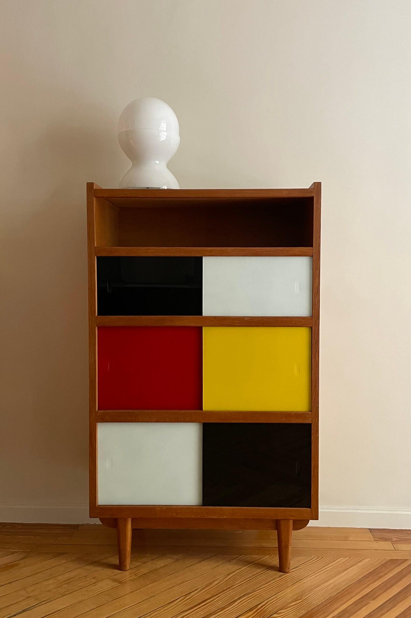 Wardrobe, wooden bookcase with sliding glass doors in different colours. France, 1960s


