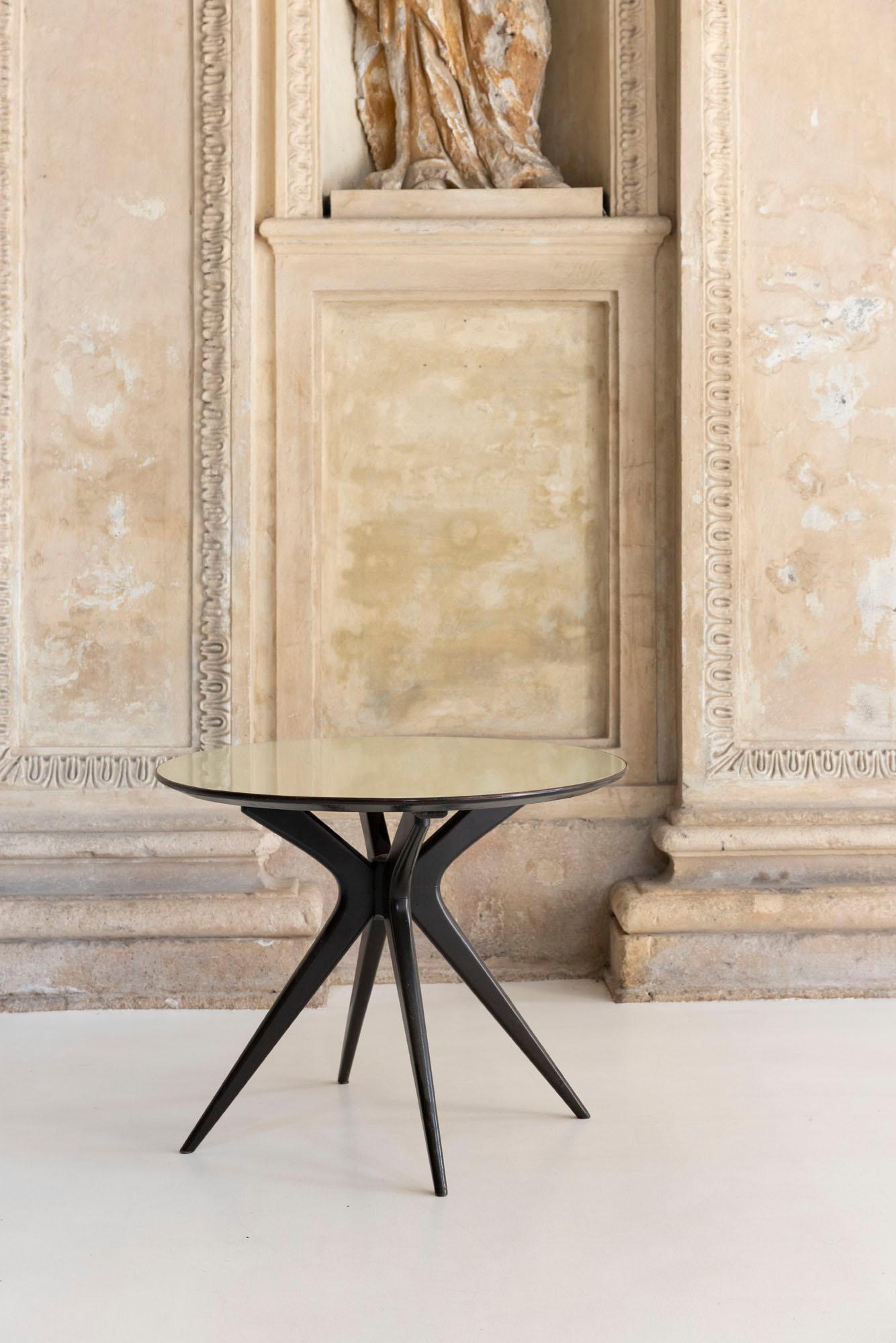 Table basse élégante conçue par Ico Parisi, dotée d'une structure sculpturale en bois aux lignes dynamiques et effilées typiques de l'esthétique raffinée du milieu du siècle de Parisi.
Le plateau de la table est en verre, ce qui permet à la