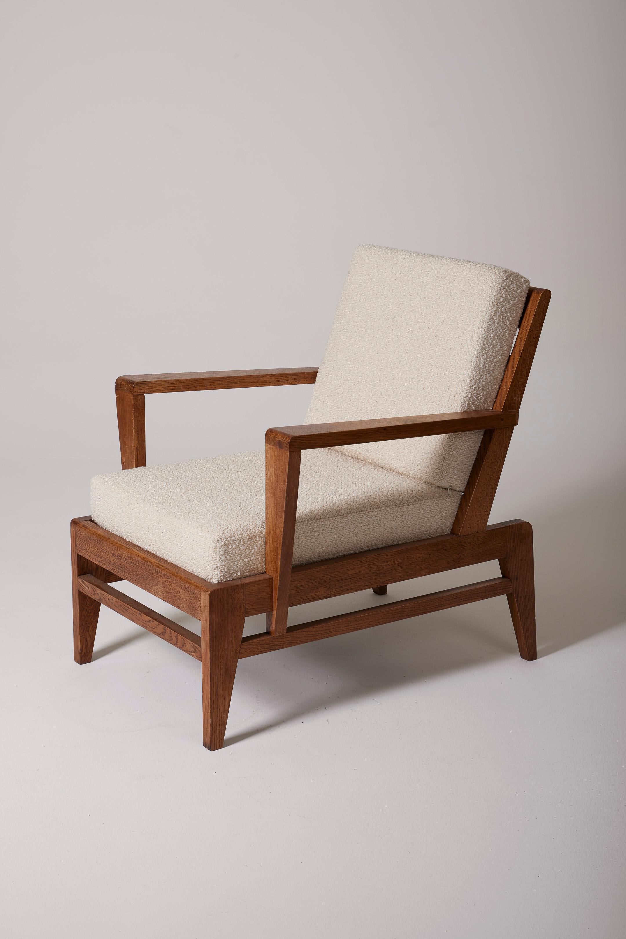 Rare armchair by French designer René Gabriel (1890-1950) from the 1950s. The armchair's frame is made of solid oak, with a beautiful patina, and the backrest and seat are upholstered in white/ecru bouclé fabric. Good overall condition. In 1944, the