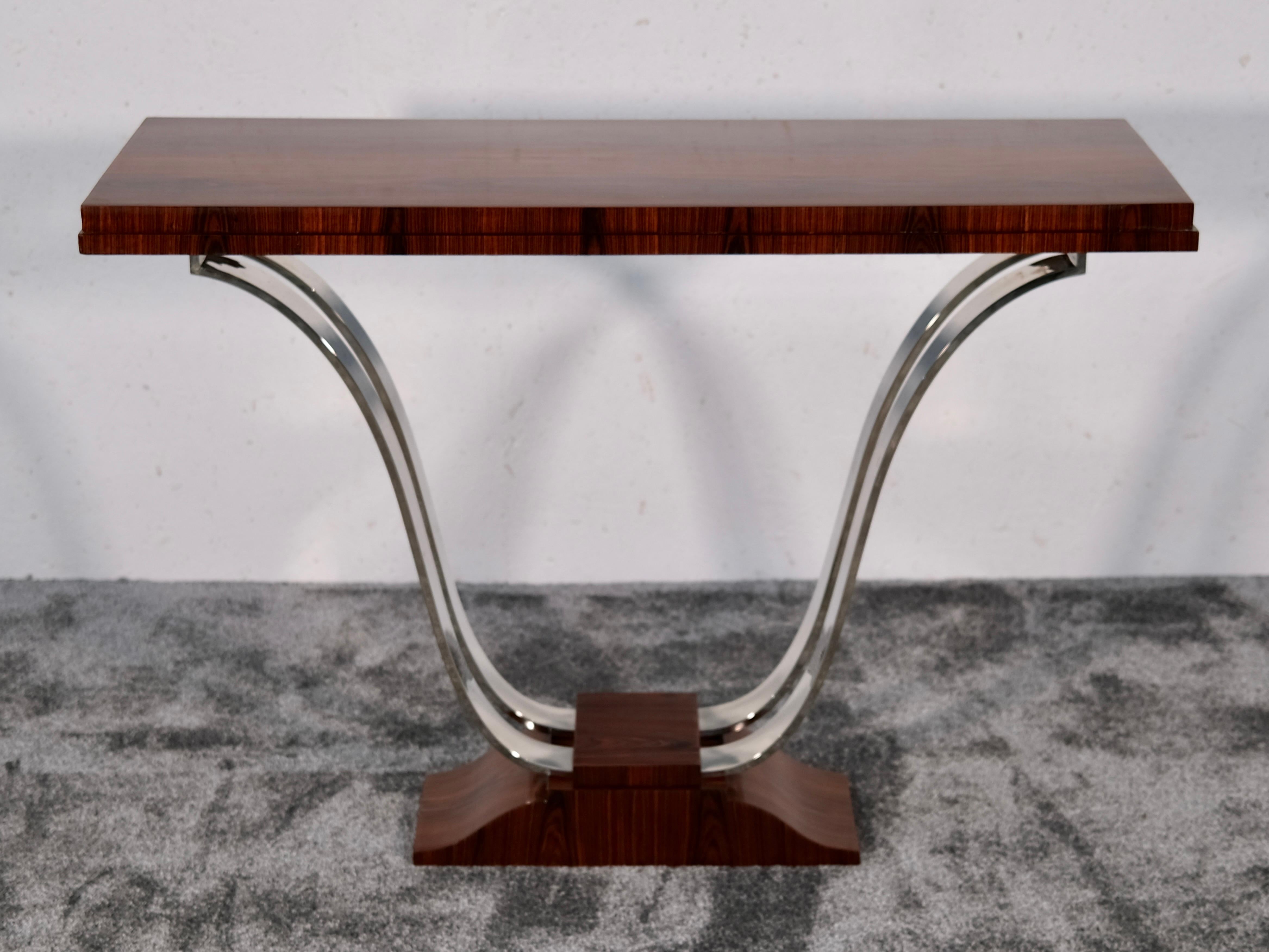 Esta exquisita consola Art Déco es una celebración de elegancia escultural y refinados contrastes. Con una anchura de 100 cm, una altura de 75 cm y una profundidad de 34 cm, tiene unas proporciones elegantes, lo bastante finas para realzar un