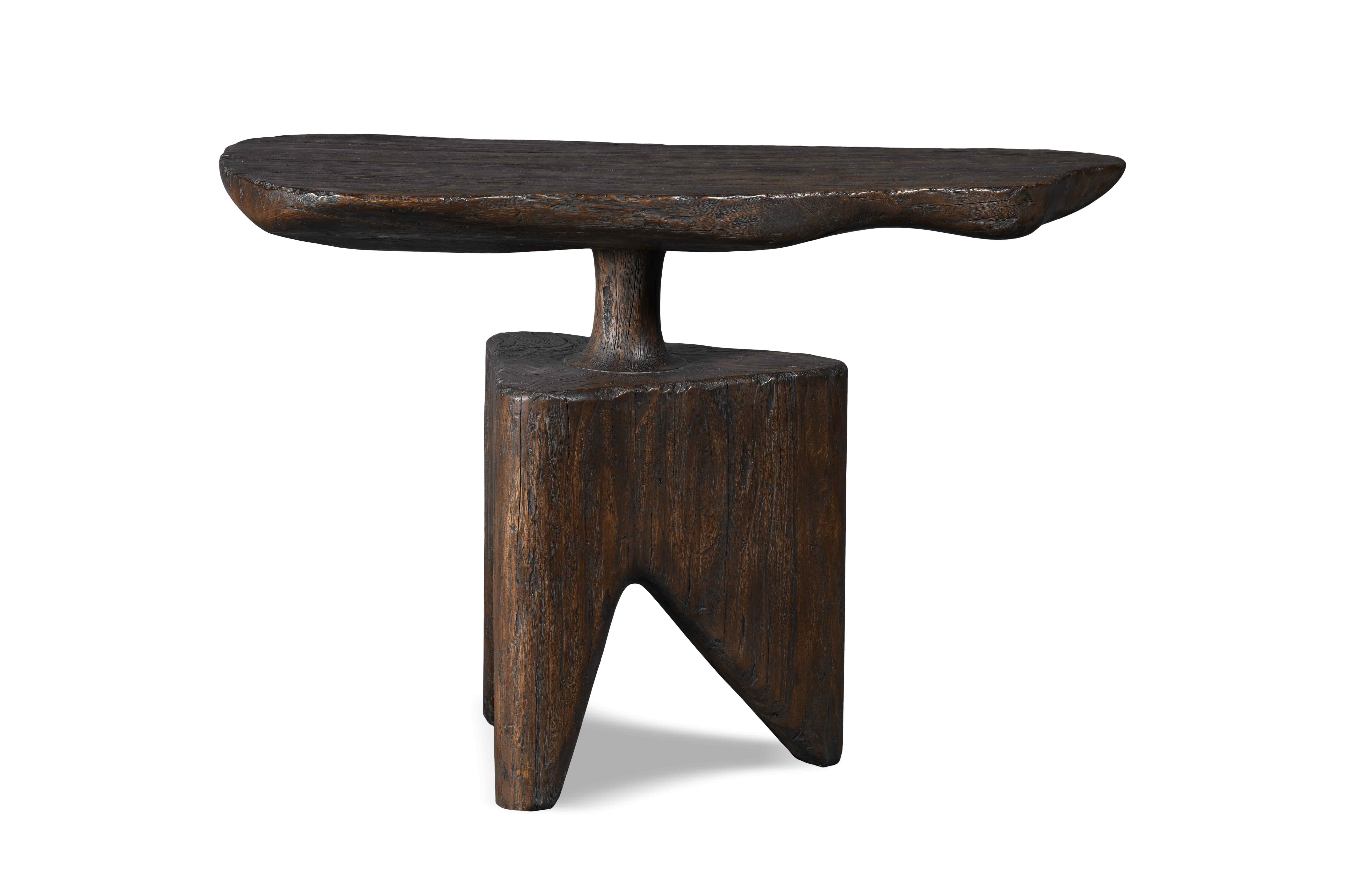 This console is eclectic in essence. Its irregularly formed base and three standing legs make it visually appealing. Its finish is rustic and sophisticated achieving an aged esthetic perfect for decorating any space.