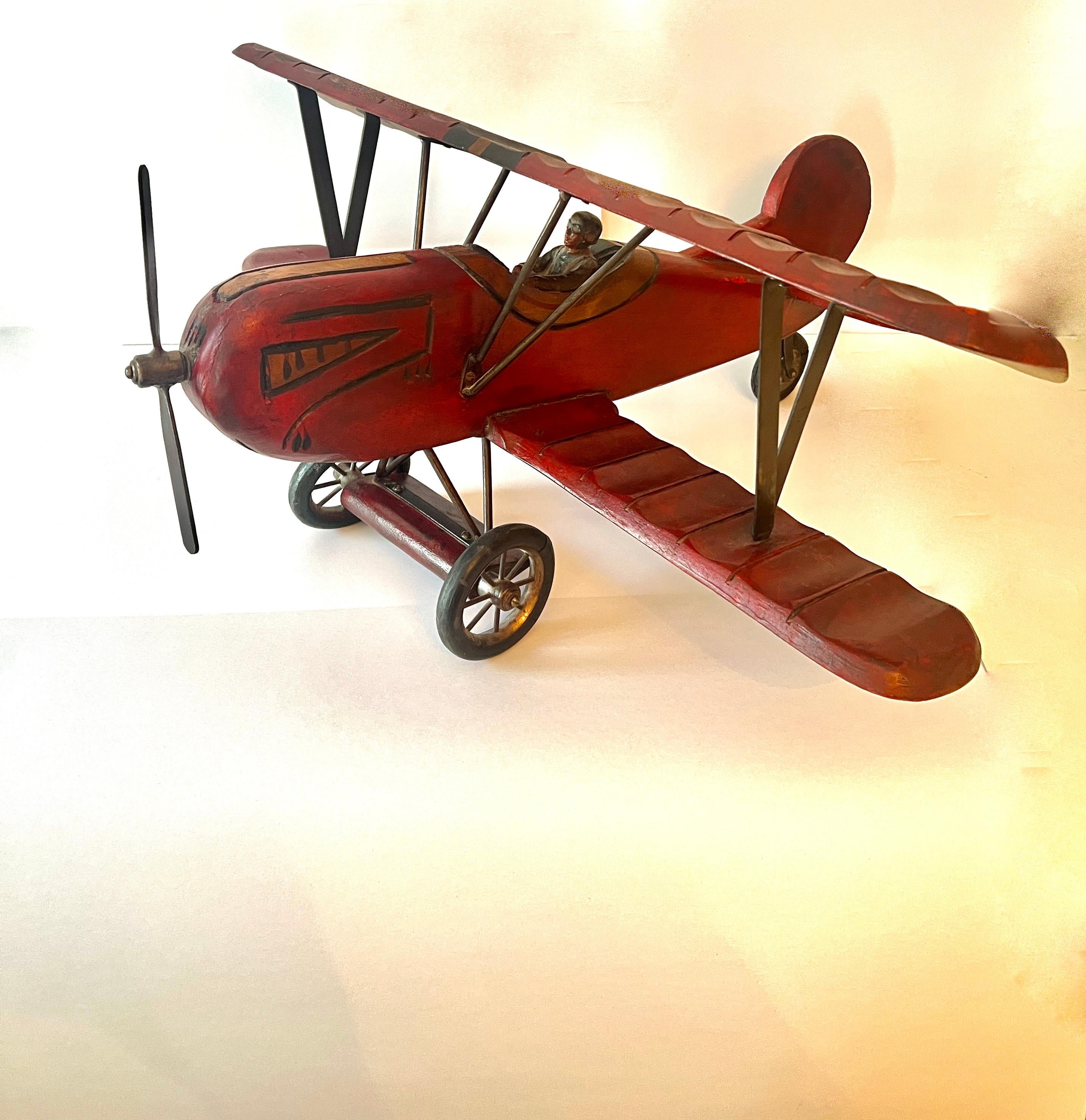 A vintage wooden Biplane Model - the plane is built like the original with a pilot and rubber wheels and a metal propeller.

A handsome addition to a shelf, console or Childs room.   also for the flight aficionado.  

In very good vintage