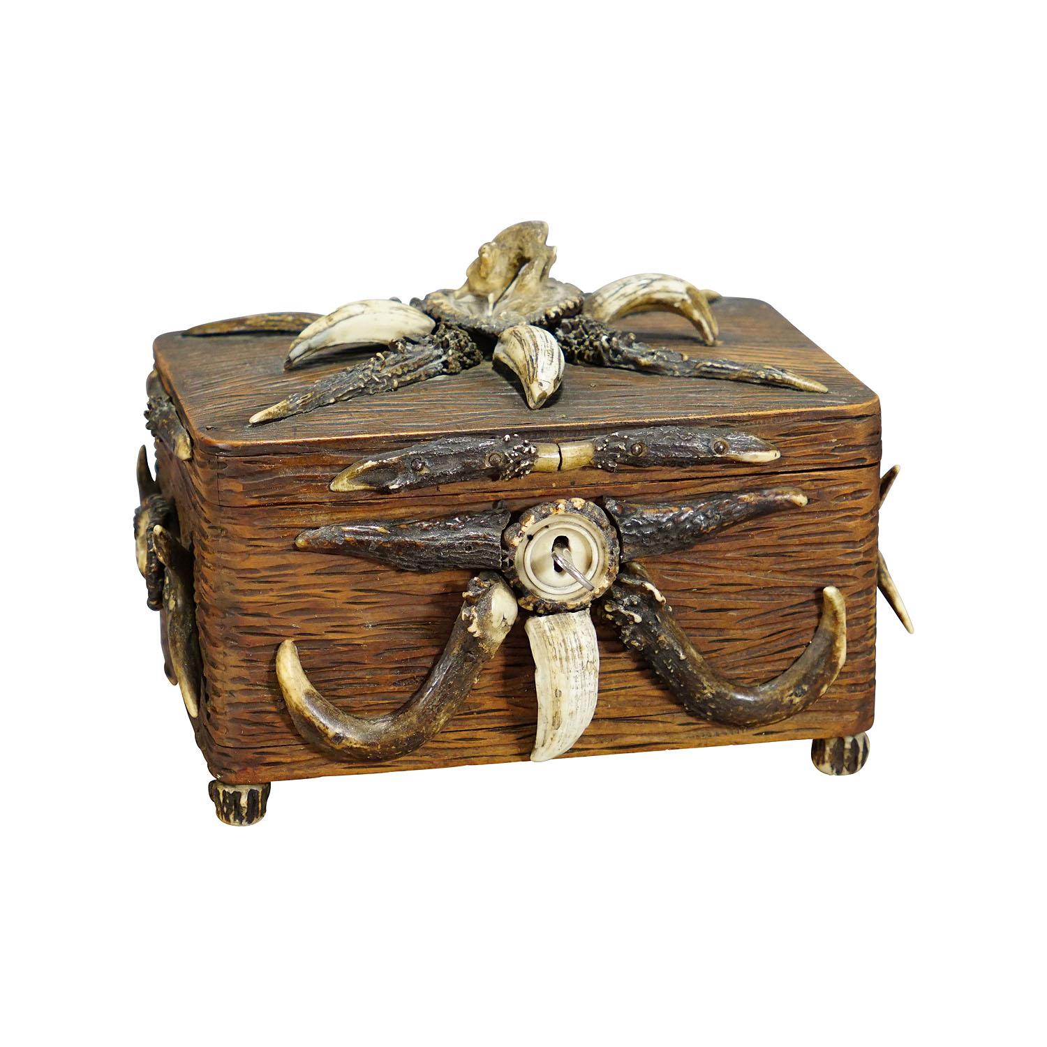 Wooden Black Forest casket with antlers decoration circa 1900s

A marvelous rustic wooden casket or cigar box. It is made of handcarved pine wood panels, decorated with several deer antler pieces and wild boar tusks, on the lid with fine carved