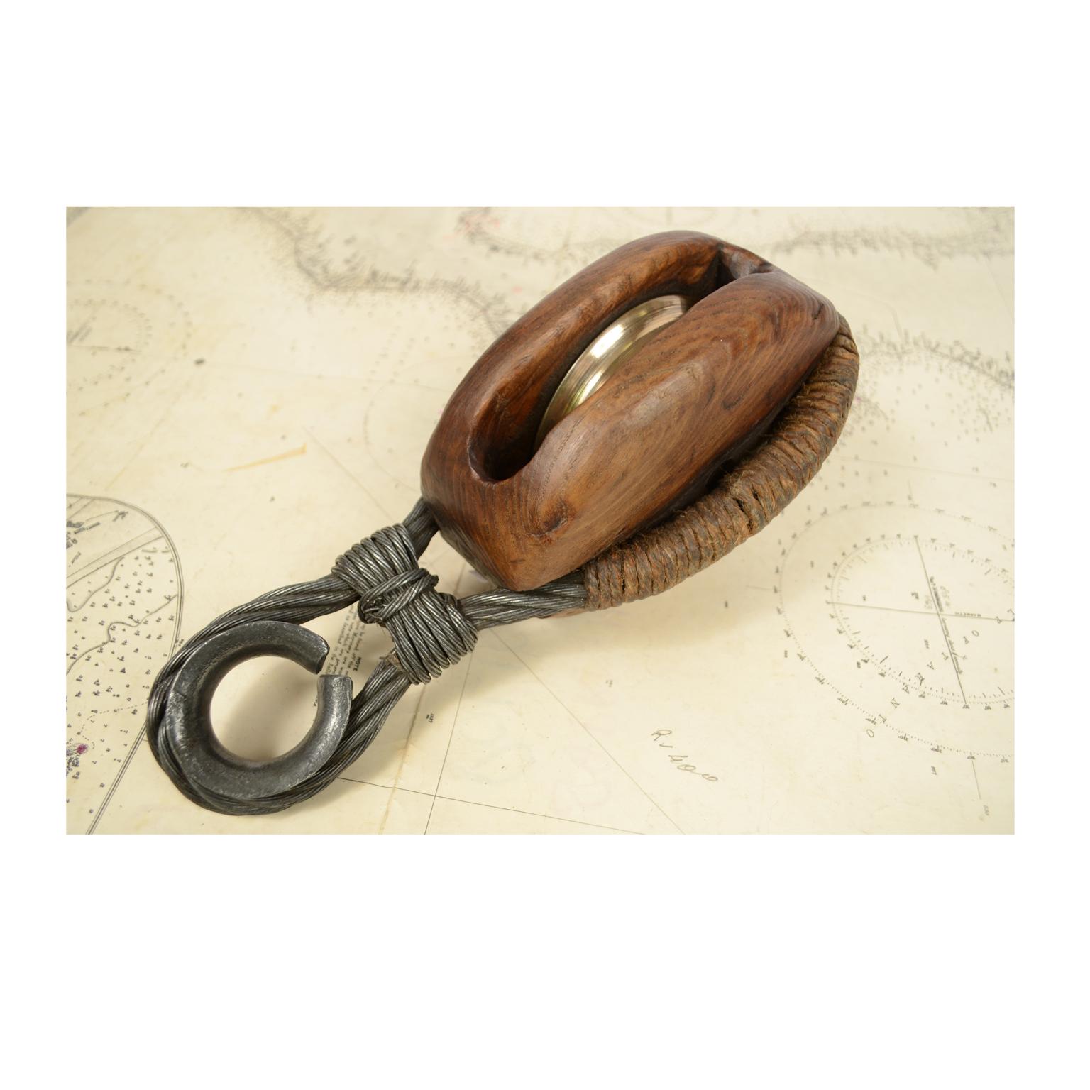 Simple wooden block complete with steel ring and rope with brass pulley, consisting of two sides inside which the pulley is placed. English manufacture of the second half of the 19th century. Measures 12 x 12 cm, length 29 cm. In excellent