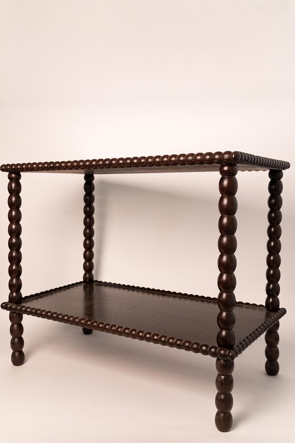 Exotic wooden bobbin table stading on four feet supporting two trays. Moçambique, 1960s. 