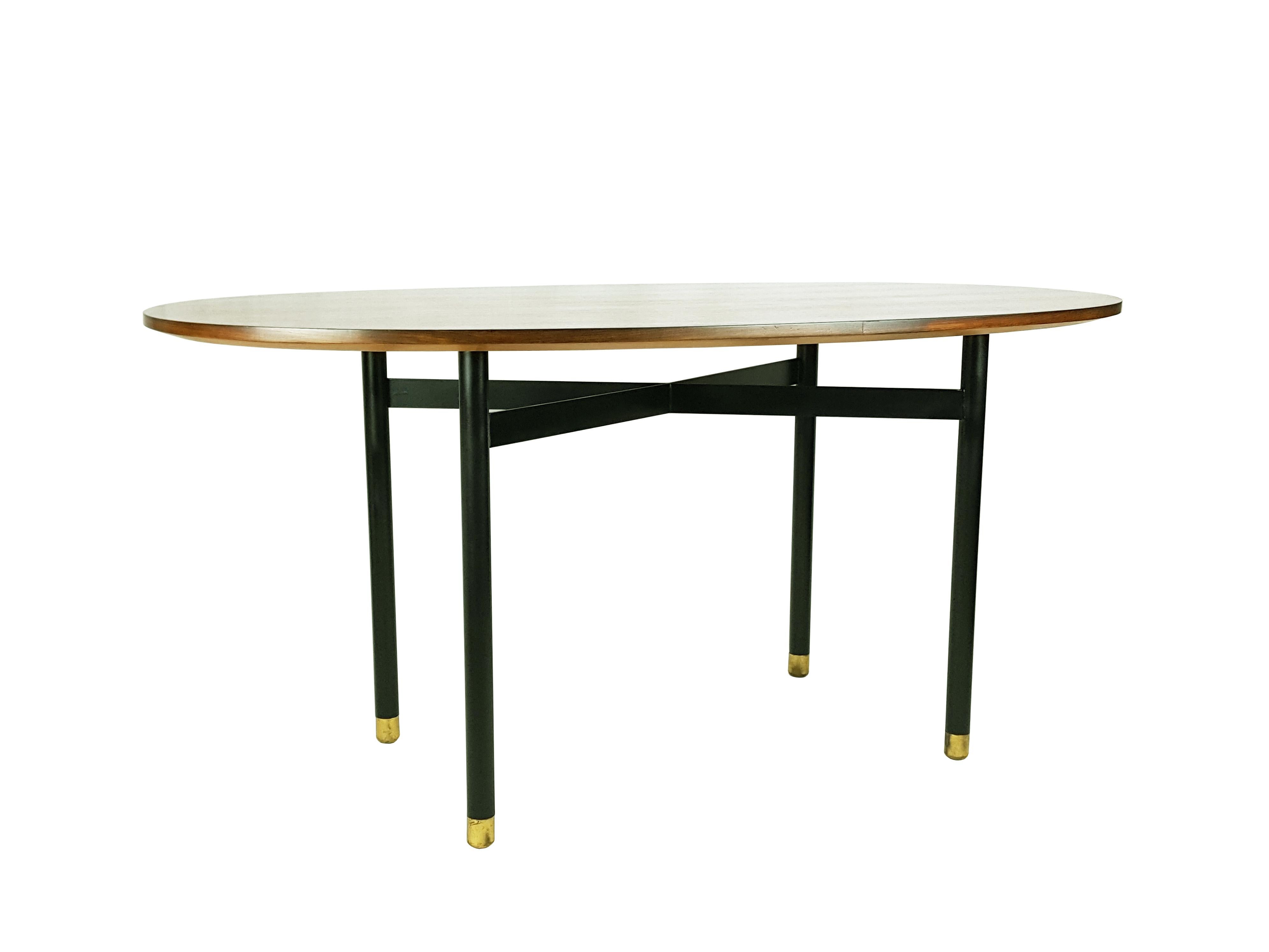 Oval dining table ideal for 4/6 persons. Table top in wood, base in black painted metal, shaped feet in brass. Very good condition: Top and metal base have been restored.