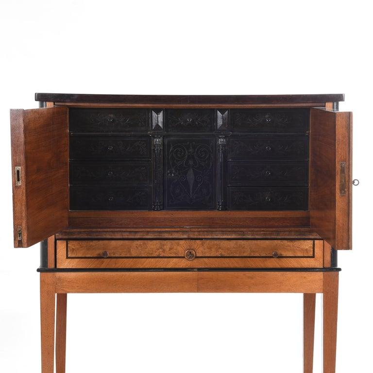 Preciosa vitrina de madera con puertas que se abren a 9 inserciones grabadas y 1 cajón inferior
Puertas interiores de madera ennegrecida grabada 
Decoración de marquetería en las puertas exteriores.