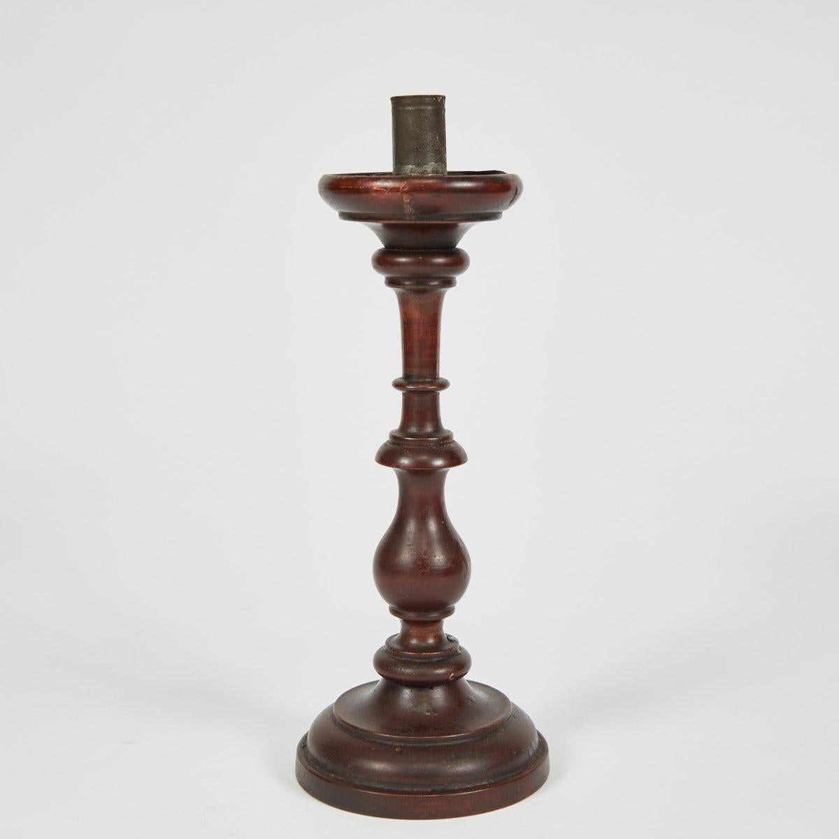 French 19th-century turned wood candlestick in walnut. With a dignified and gracious air, this well-patinated piece brings a warm sophistication to any environment. 

France, circa 1860

Dimensions: 4W x 4D x 11H
