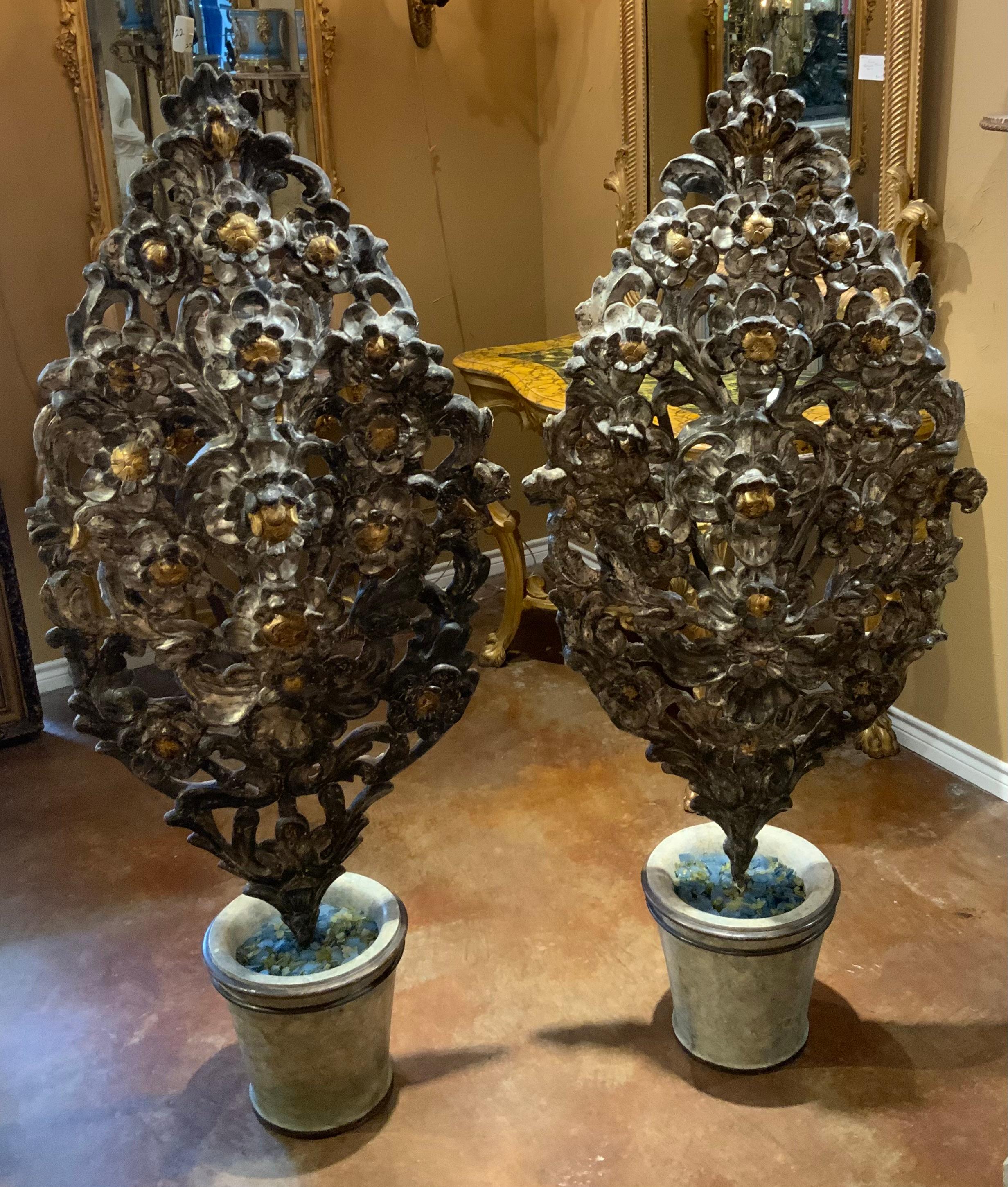 These are hand carved sculptures in the shape of a tree
The elements are gilded in silver and gold gilt hues.
They are set in a faux marble planter. They are beautifully 
Carved and would be highly decorative placed by doorways
Or flanking a mantel