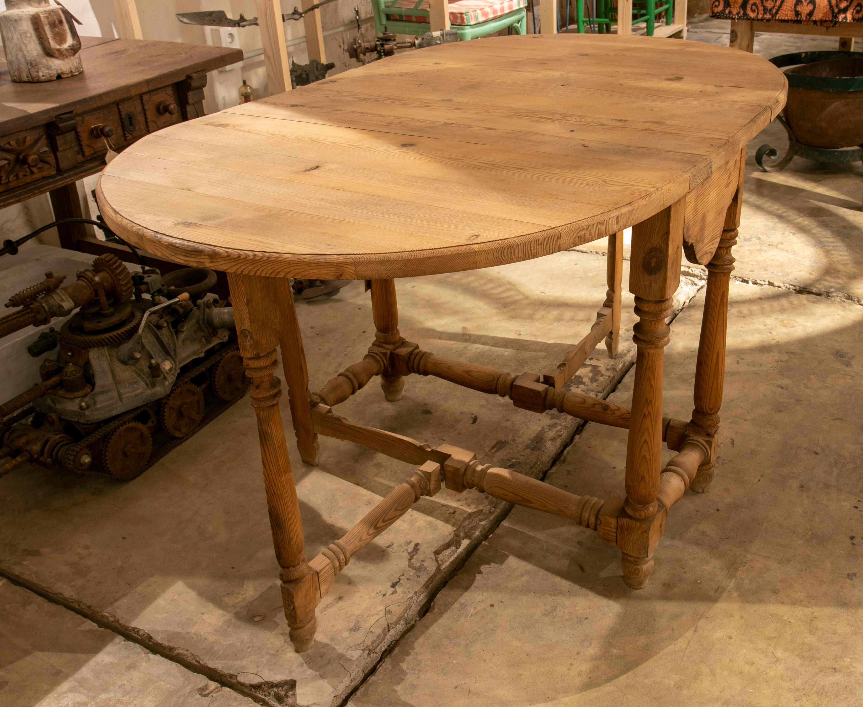 Wooden carved wing table with turned legs and hinged sides.