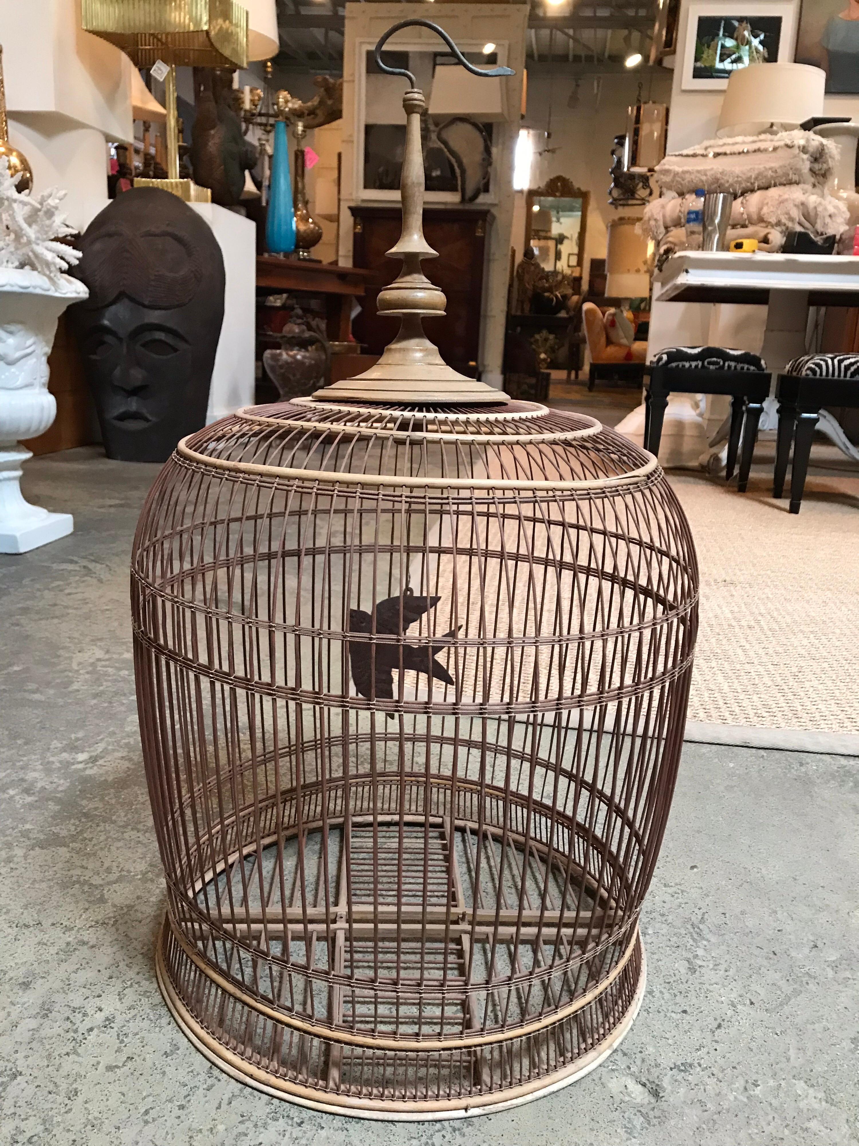 This Chinese birdcage is handmade from thin pieces of wood. It has a thin metal piece inside that's stamped and shaped to resemble a bird.