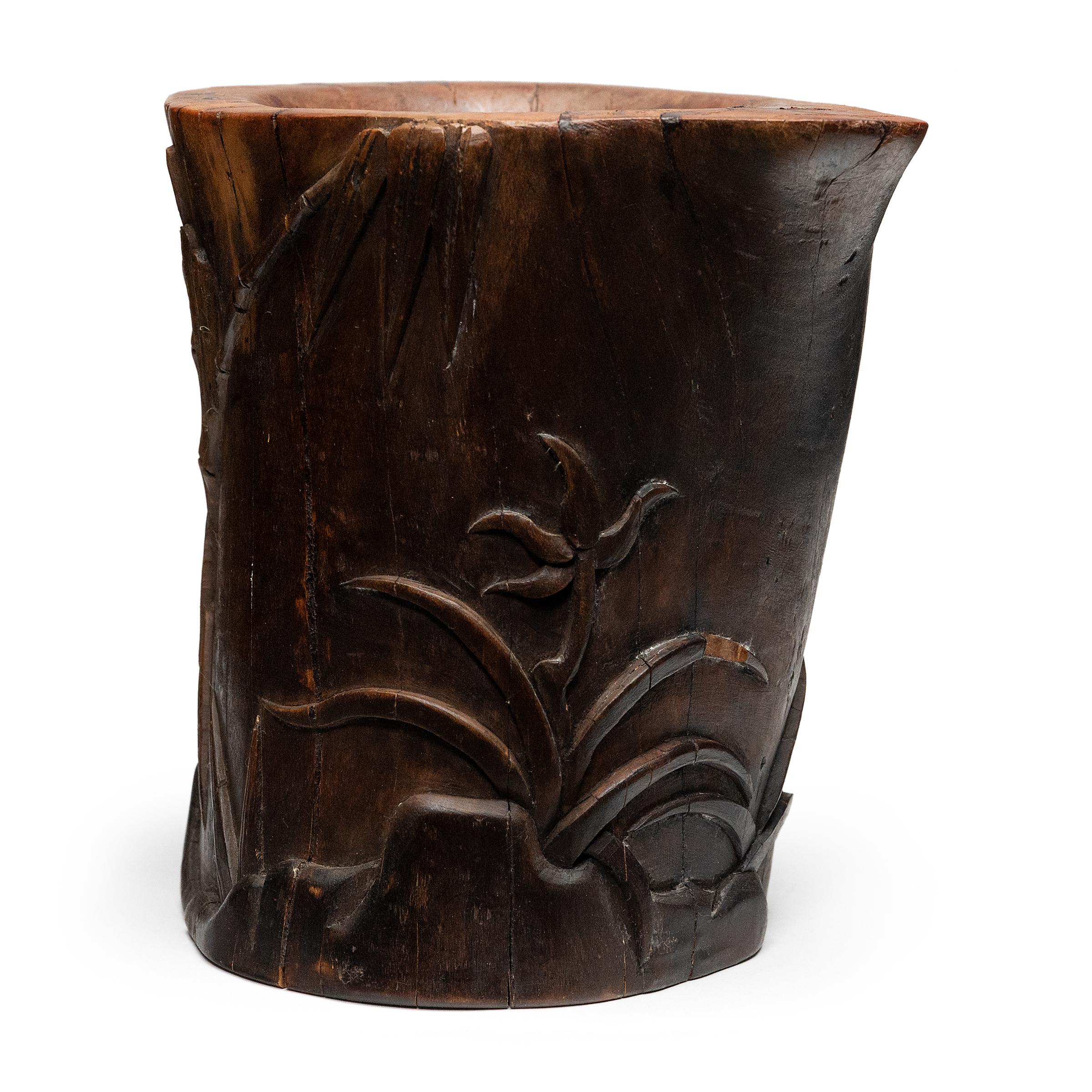 Set alongside the four treasures of the study - the calligraphy brush, ink, paper, and inkstone - a brush pot, or bitong, was an essential fixture of the scholars' desk. This eye catching example is carved from a solid block of wood with low relief