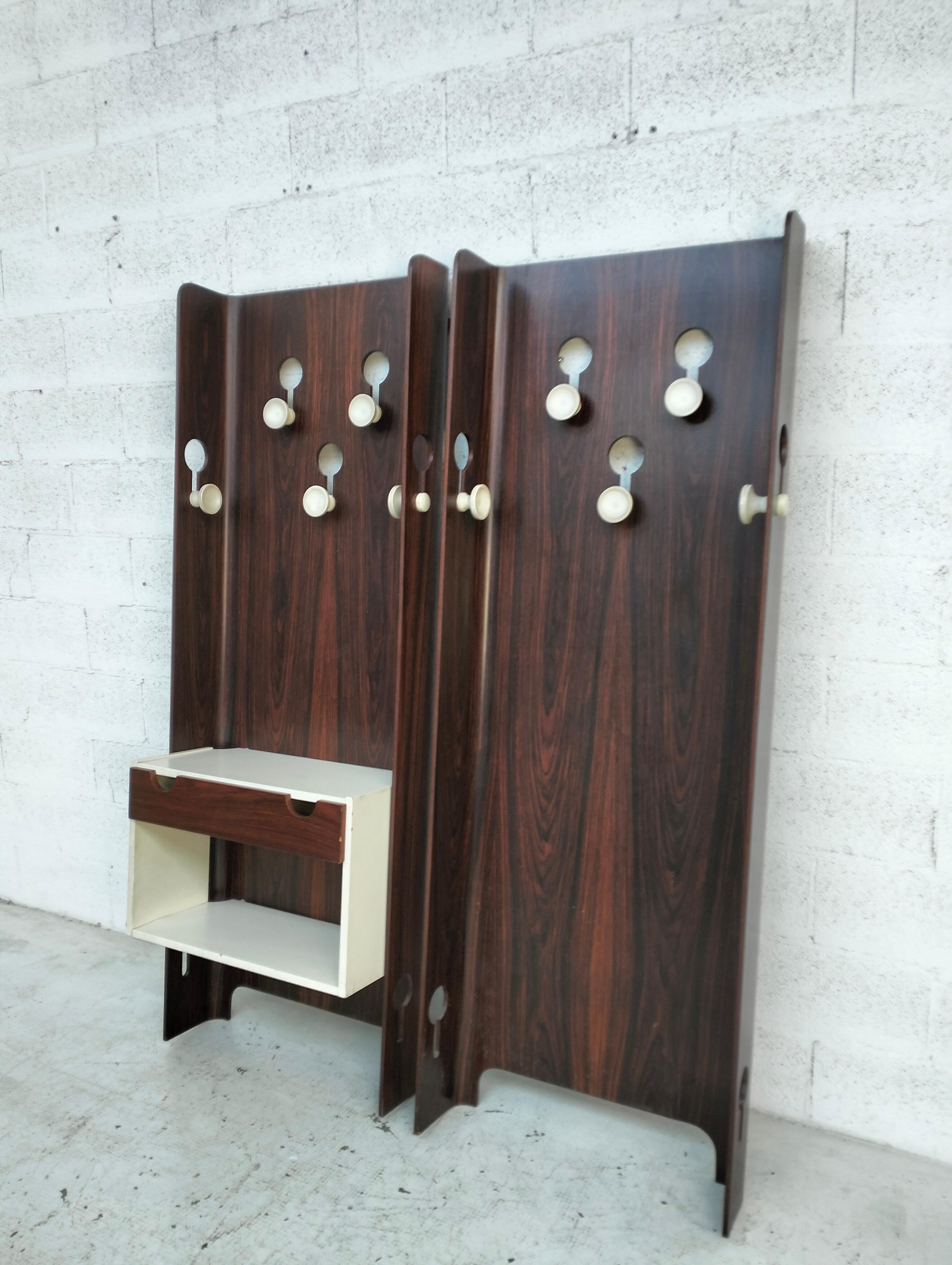 Juego de perchas modulares fabricado por FIARM Scorzè en Italia en los años 60. Diseño Carlo De Carli. De madera curvada con orificios para alojar los pomos de baquelita. Cómoda de madera lacada con frente de cajón en nogal.

Carlo De Carli (Milán,