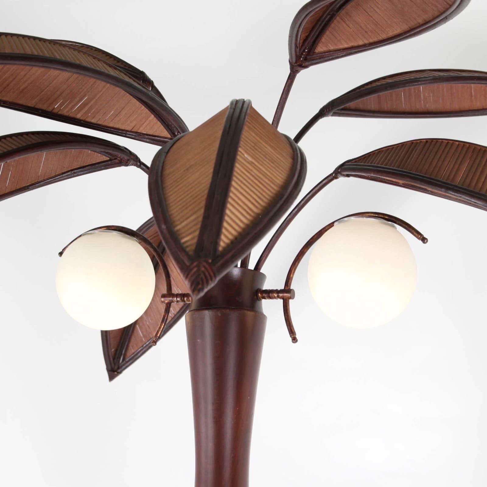 Rare wooden floor lamp in the shape of a coconut tree.
10 rattan palms that come off for the shipping, 2 lights the glass globes « coconuts ».
Very decorative piece in good condition.