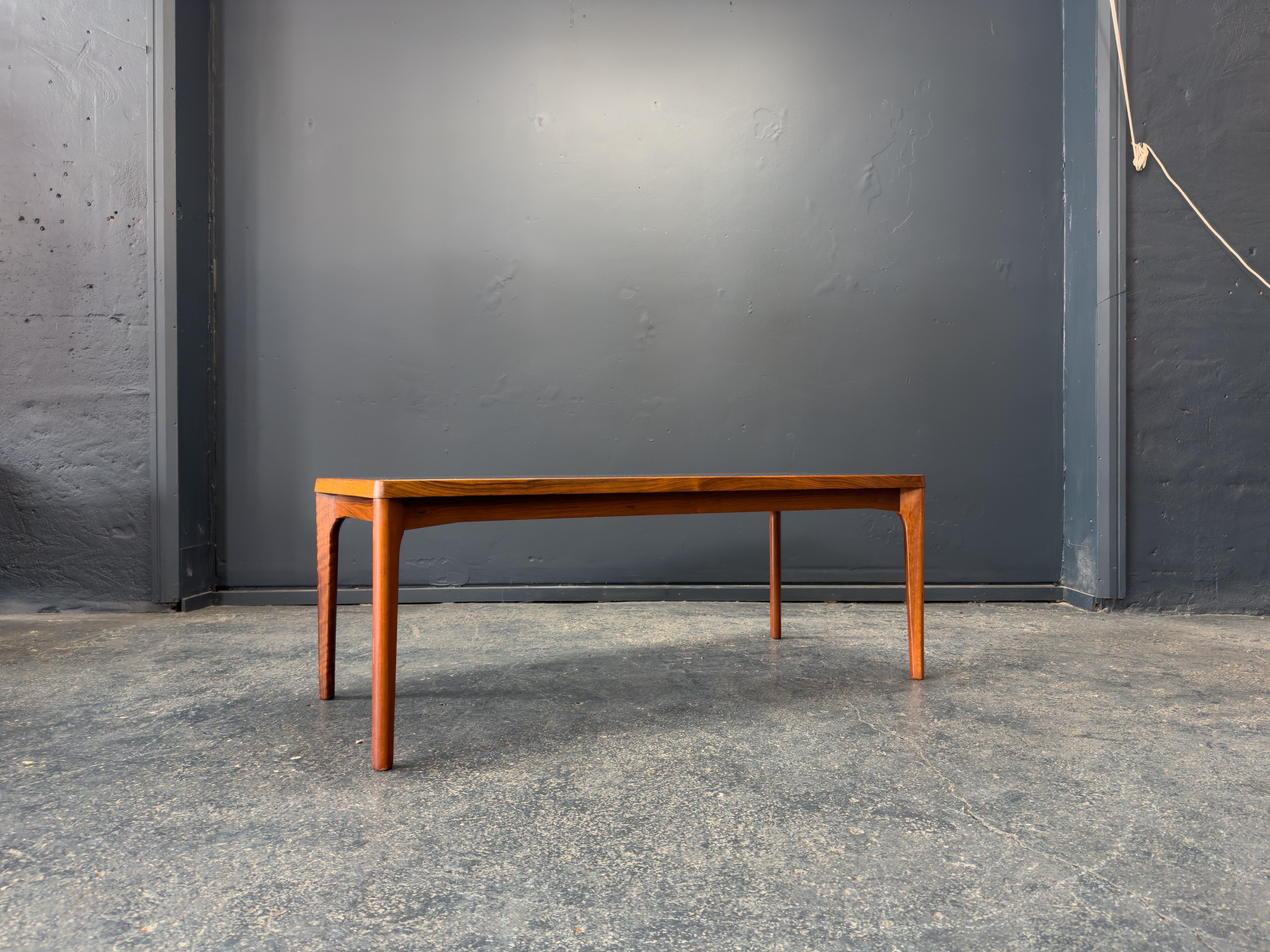 Cette table basse raffinée est un exemple frappant de l'artisanat moderne du milieu du siècle, combinant des lignes épurées avec une matérialité sophistiquée. La table est dotée d'un plateau en bois magnifiquement grainé, présentant de riches motifs