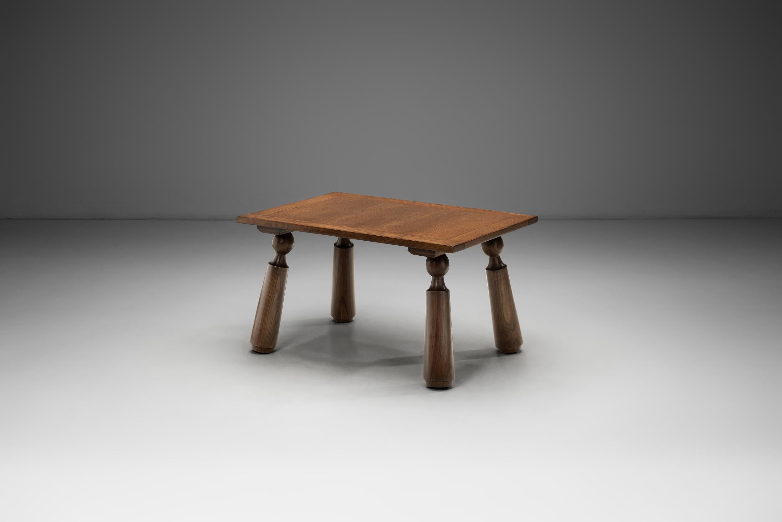 Cette table basse en bois, fabriquée en France dans la première moitié du XXe siècle, est conçue à la manière de Charles Dudouyt, l'une des figures les plus marquantes des arts décoratifs français de l'entre-deux-guerres. Le travail de By Design/One