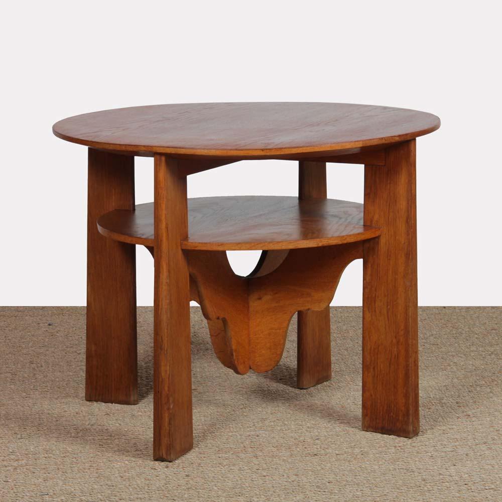 This oak pedestal table dates from the 1940s. It has a two-level top. It bears the iron mark of a cabinetmaker. The table is in good original condition, with a restored top.