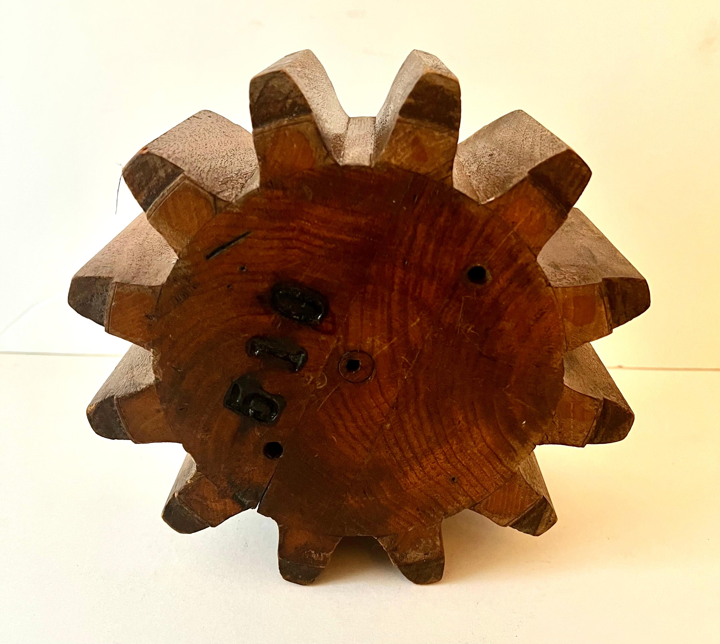 A wooden piece of a gear or a wooden Cog.  An old architectural Element.  These pieces are wonderful filler on a side table or console table that is telling an interesting story.  This could also be hung on a wall, or used as a paperweight.  

A