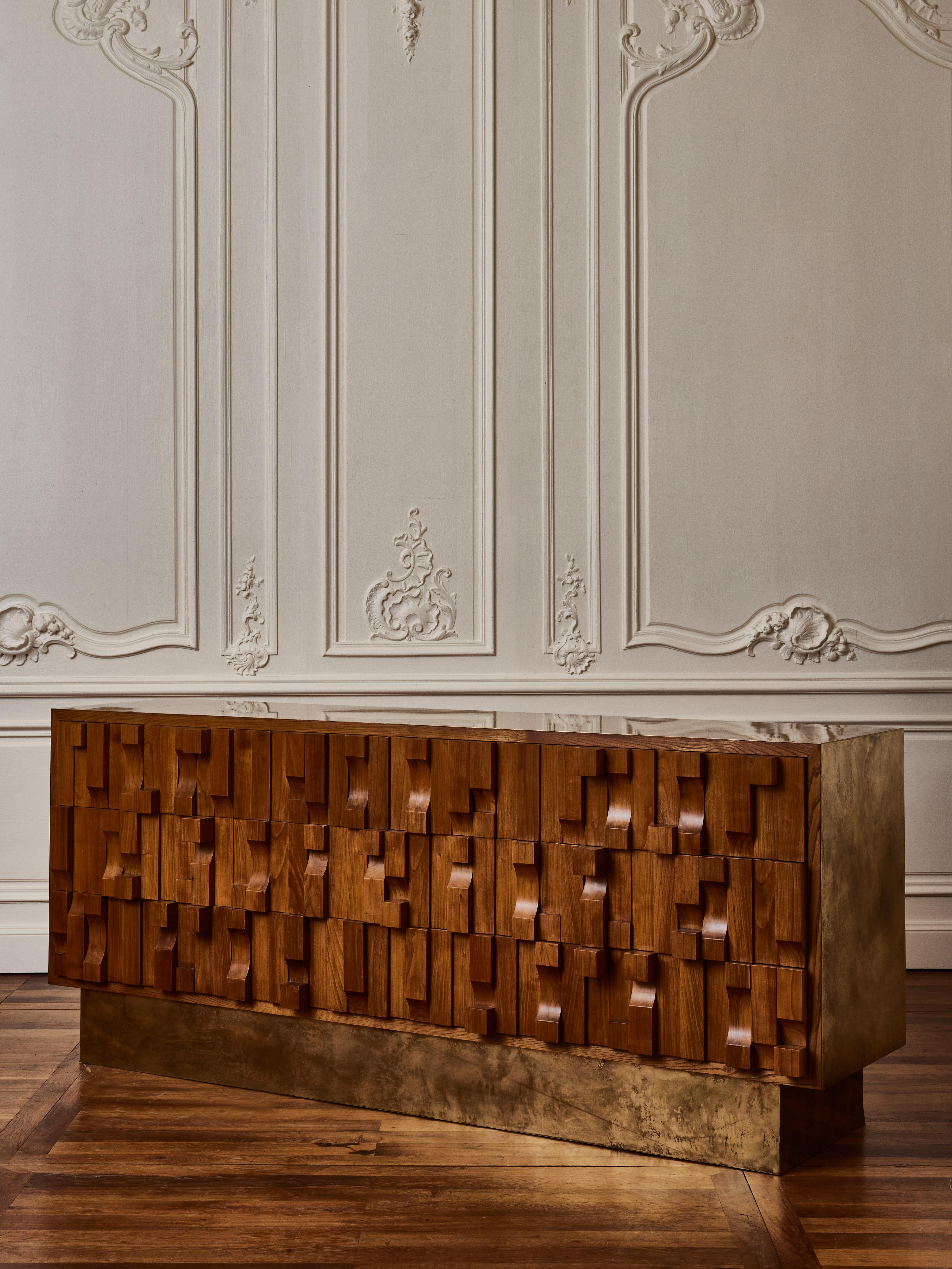 Kommode aus geschnitztem Holz mit Holz und Platte aus säurepatiniertem Messing.
Gestaltung durch das Studio Glustin.