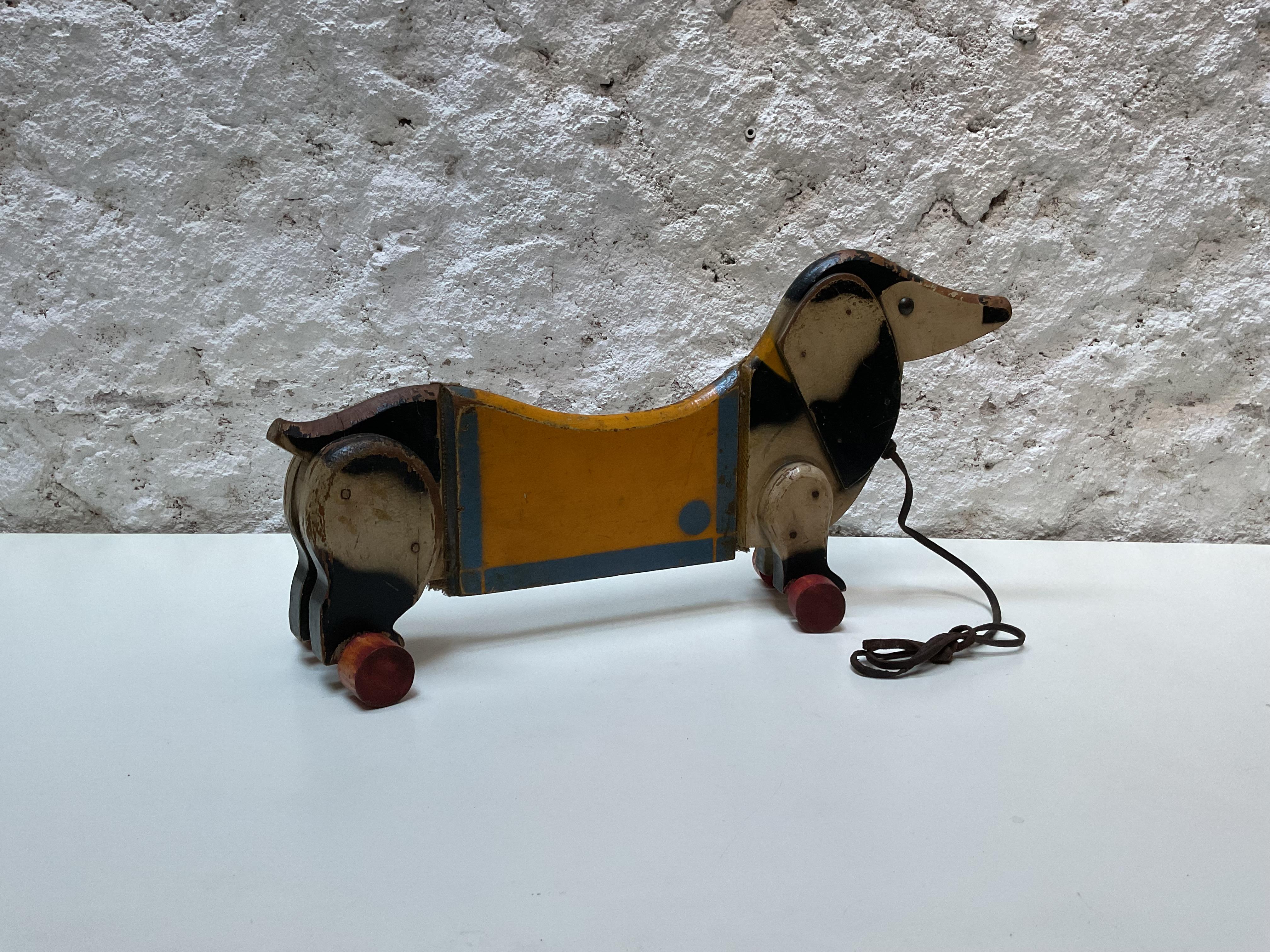 Hölzernes Dackel-Ziehspielzeug auf Rädern, CIRCA 1940

Charmantes hölzernes Dackel-Ziehspielzeug auf Rädern, hergestellt um 1940. Dieses entzückende Stück fängt den Geist des Spielzeugdesigns des frühen 20. Jahrhunderts ein und verbindet