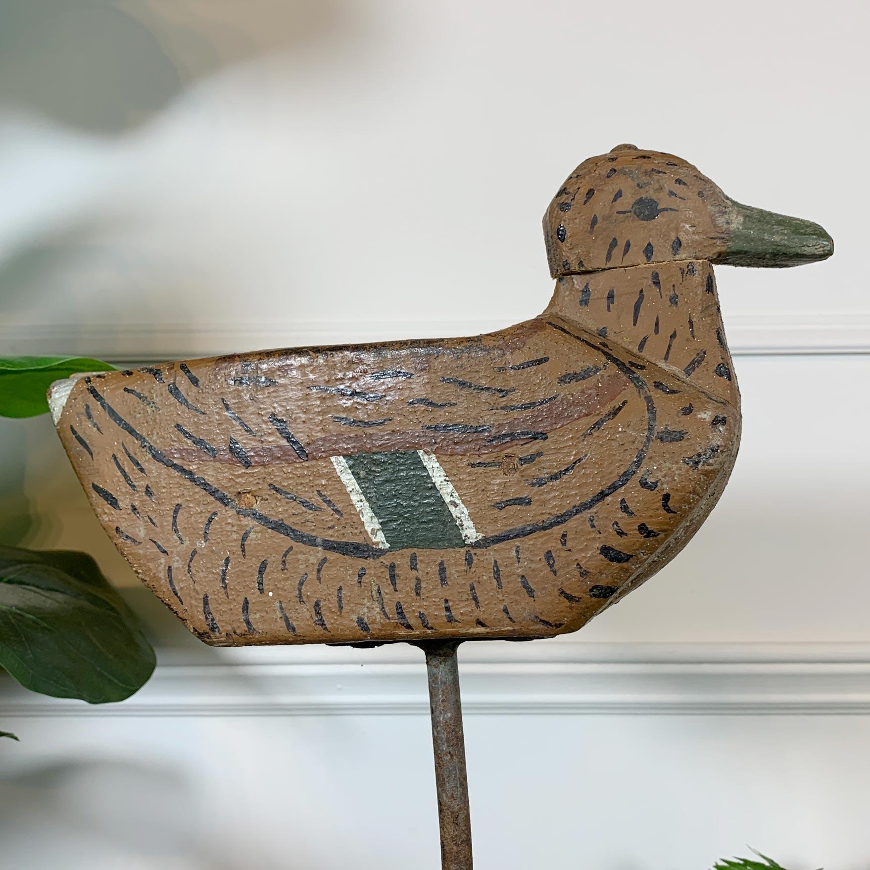 Beautiful early 20th century French decoy duck. Hand carved in wood and hand painted, the decoy has a movable head that can be turned left or right, it is also mounted on a long iron pole which allowed it to be easily pushed into the ground wherever