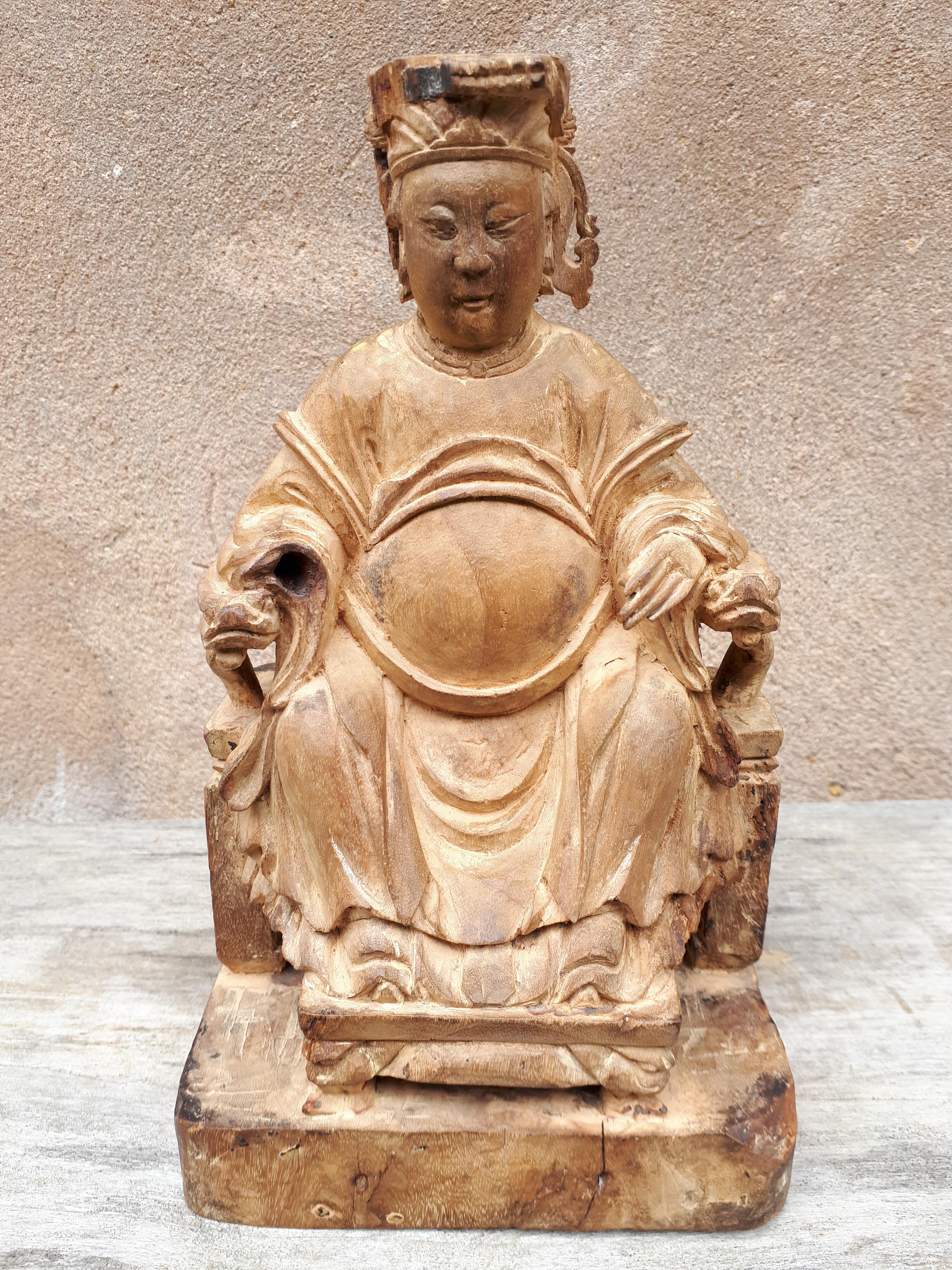 Statue of a Taoist god in wood, represented seated on a seat with armrests in the shape of heads of dragons. The face is really beautifully rendered, as well as the draping of the costume. It is a statue of very good quality !
Small loss to the