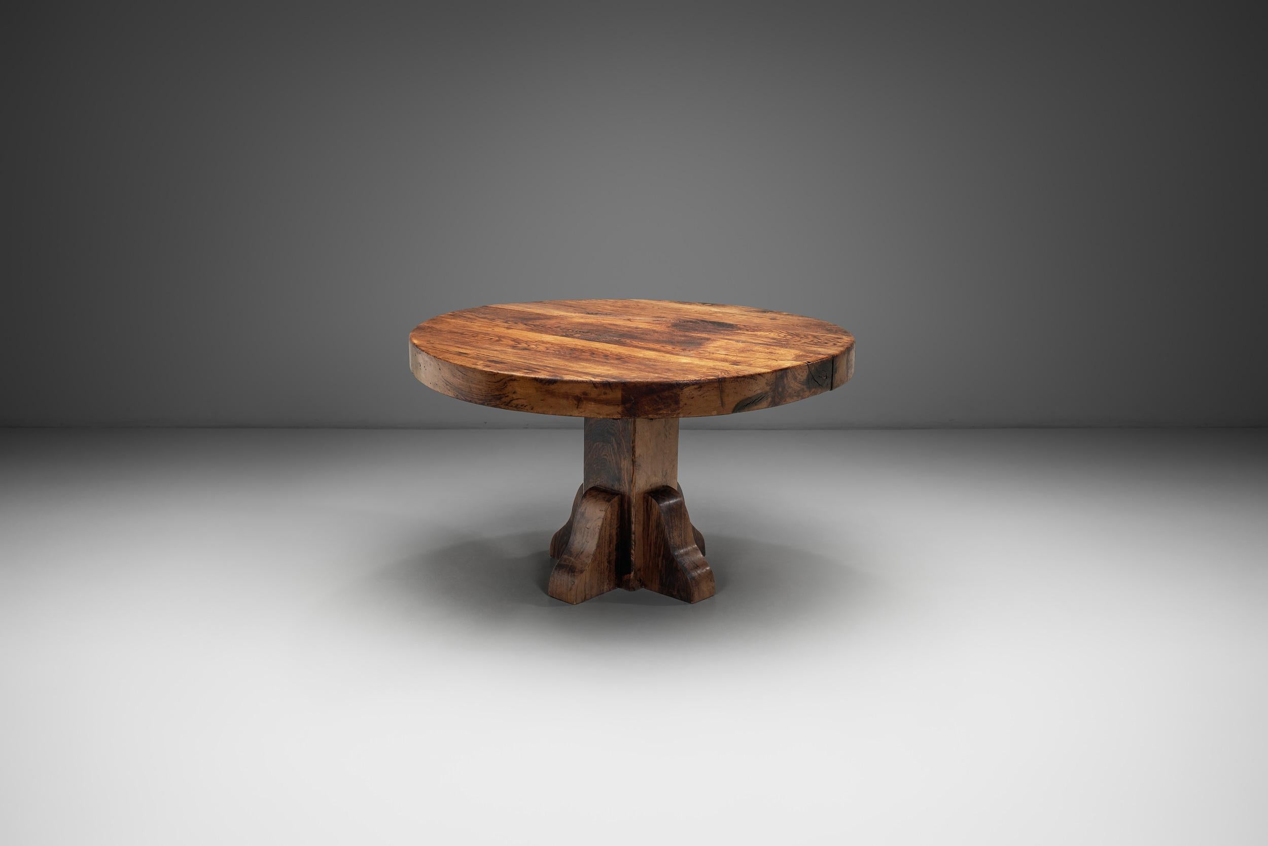 This circular table embodies the essence of European mid-century design with its distinct features that harken back to a time when form and function were paramount. Crafted from solid wood, this table exudes a rustic charm and robust aesthetic that
