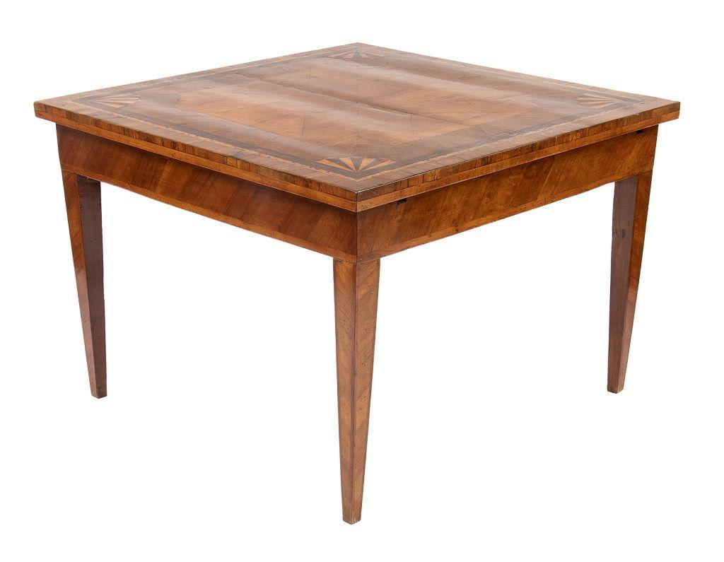 This wooden dining table is a piece of original design furniture realized in the late 19th century.

A beautiful herringbone walnut veneered table with geometric fruitwood inlays; square top and tapered legs.

This object is shipped from Italy.