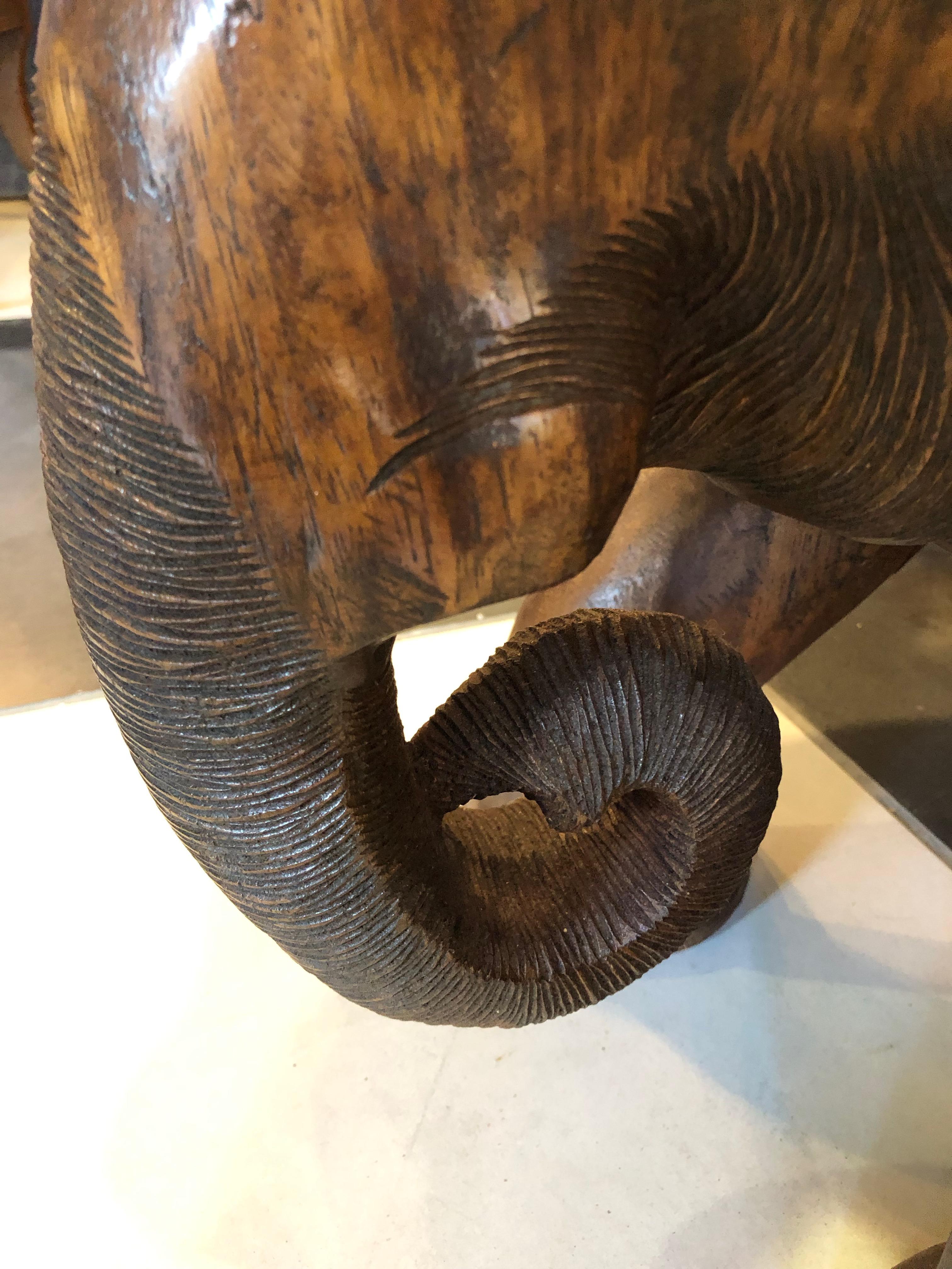 The whimsical elephant is handcrafted from one tree, one piece of wood, note the circular design of the tree trunk. Trunk curled up for 