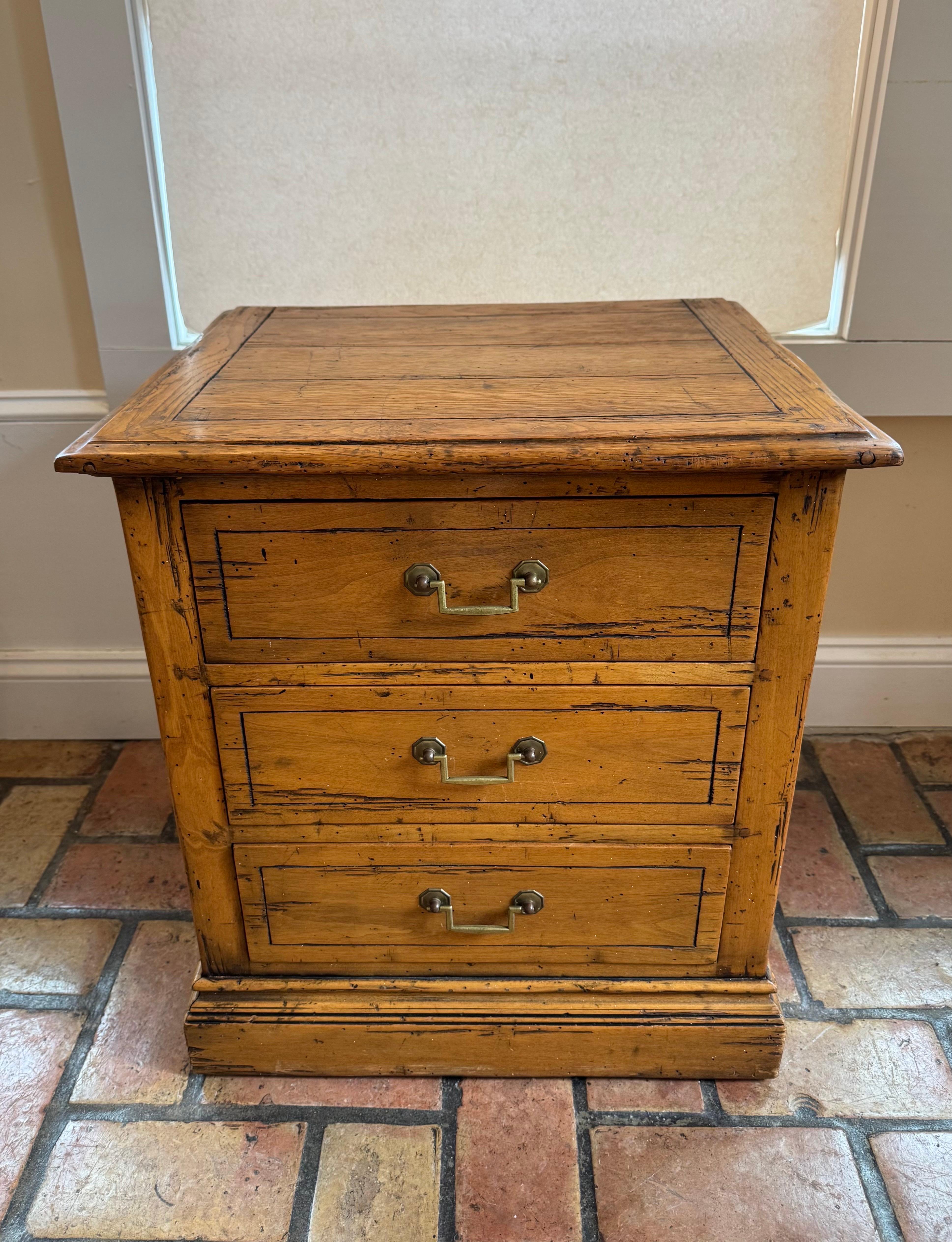 Wooden Farmhouse Three drawer Chest. Perfect as a nightstand or end table.  Distressed style with Solid brass hardware. Most likely ash or oak wood. Dimensions are: 18