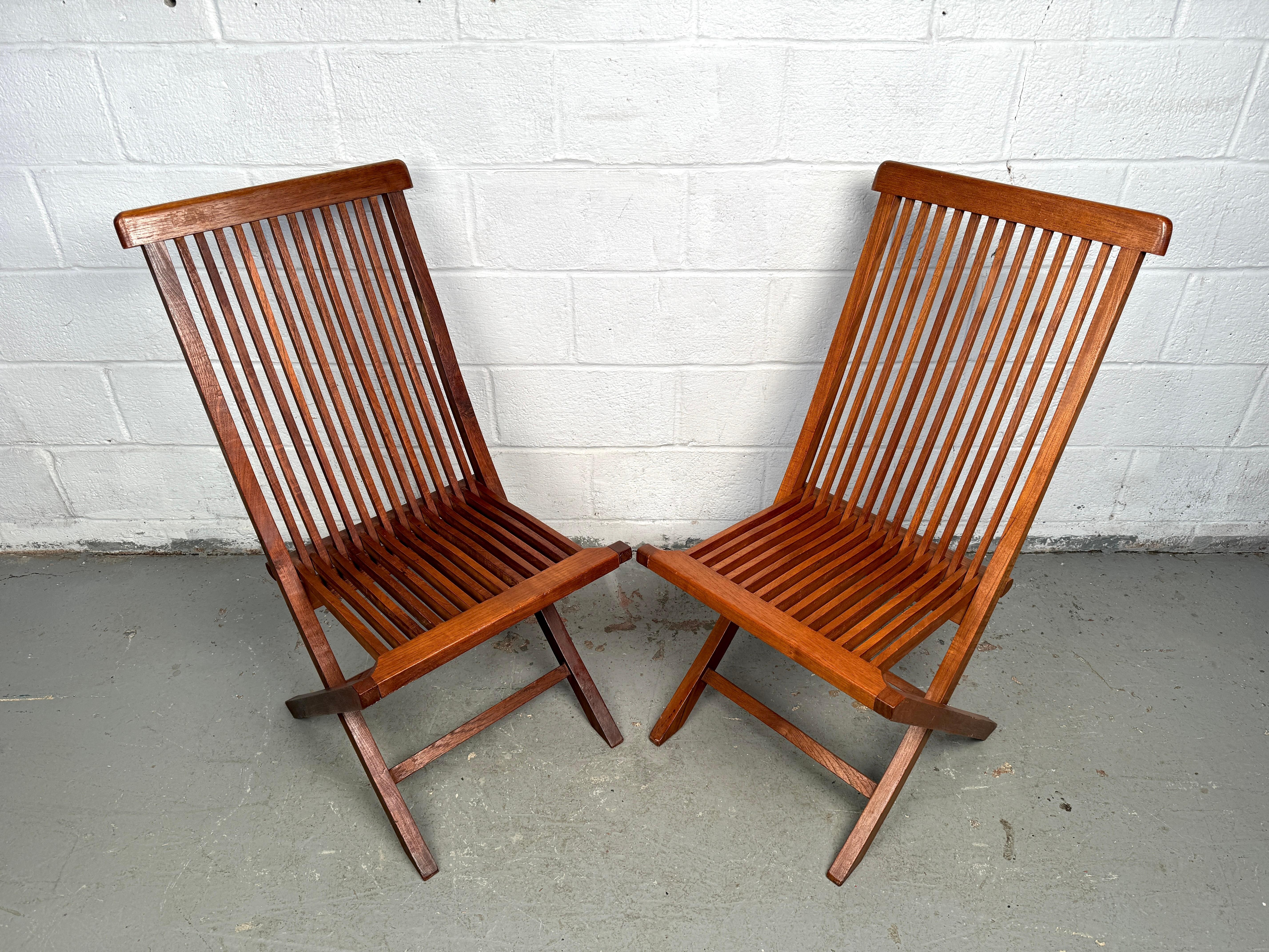 Un bellissimo set di sedie da giardino danesi in teak massiccio, dal design senza tempo della metà del secolo scorso. Queste sedie presentano linee pulite, doghe delicatamente ricurve e una patina calda che mette in risalto le venature naturali del