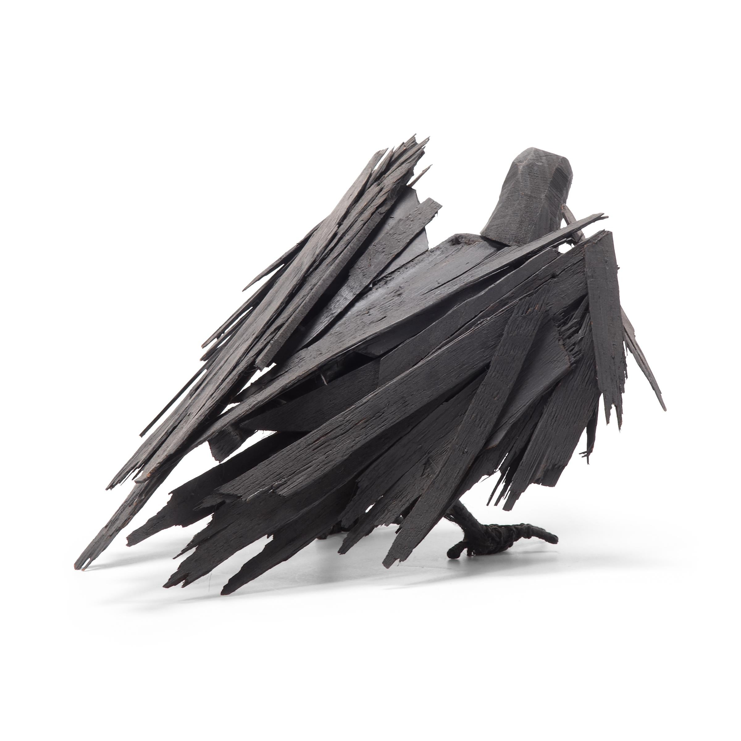Richly textured with whimsical appeal, this late 20th century wooden crow is a delightful example of naive American sculpture. Poised mid-caw, it is hard to tell whether this crow has just landed or is ready to burst into flight. As though life