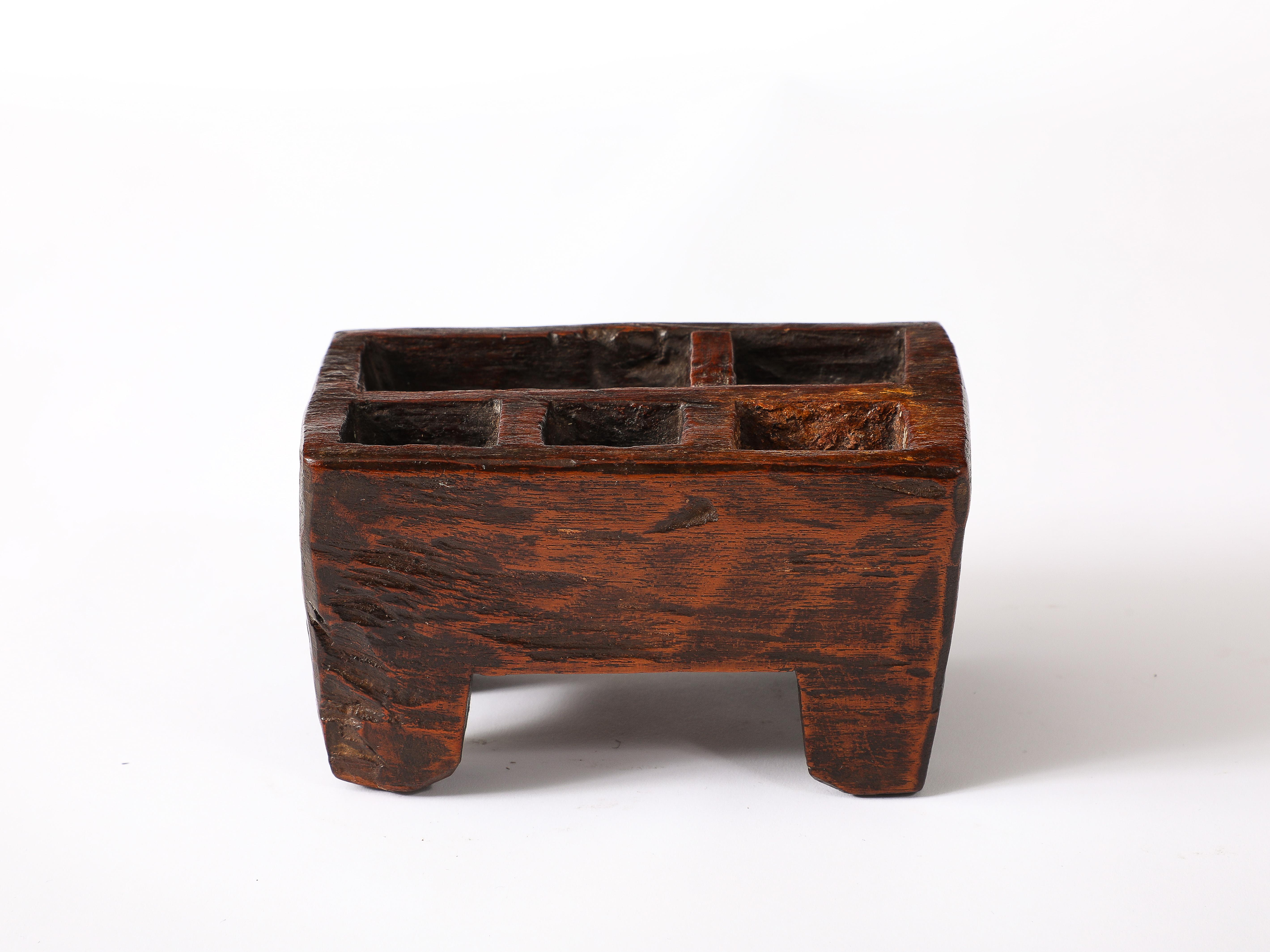 A footed tray in what appears to be solid Elm, most likely a single-purpose object carved by a craftsman, can be used for rings.

