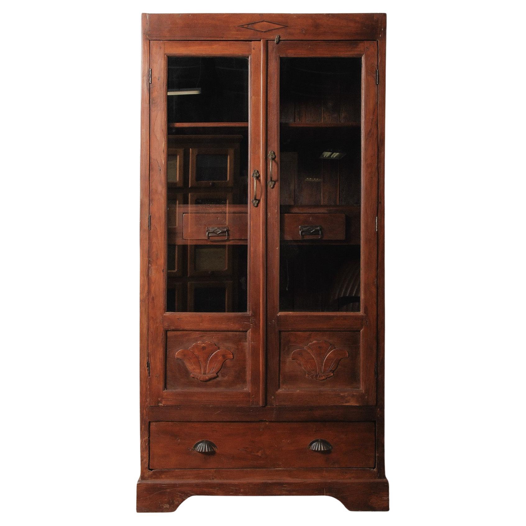 Armadio in legno con ante in vetro, pannelli intagliati e cassetti interni