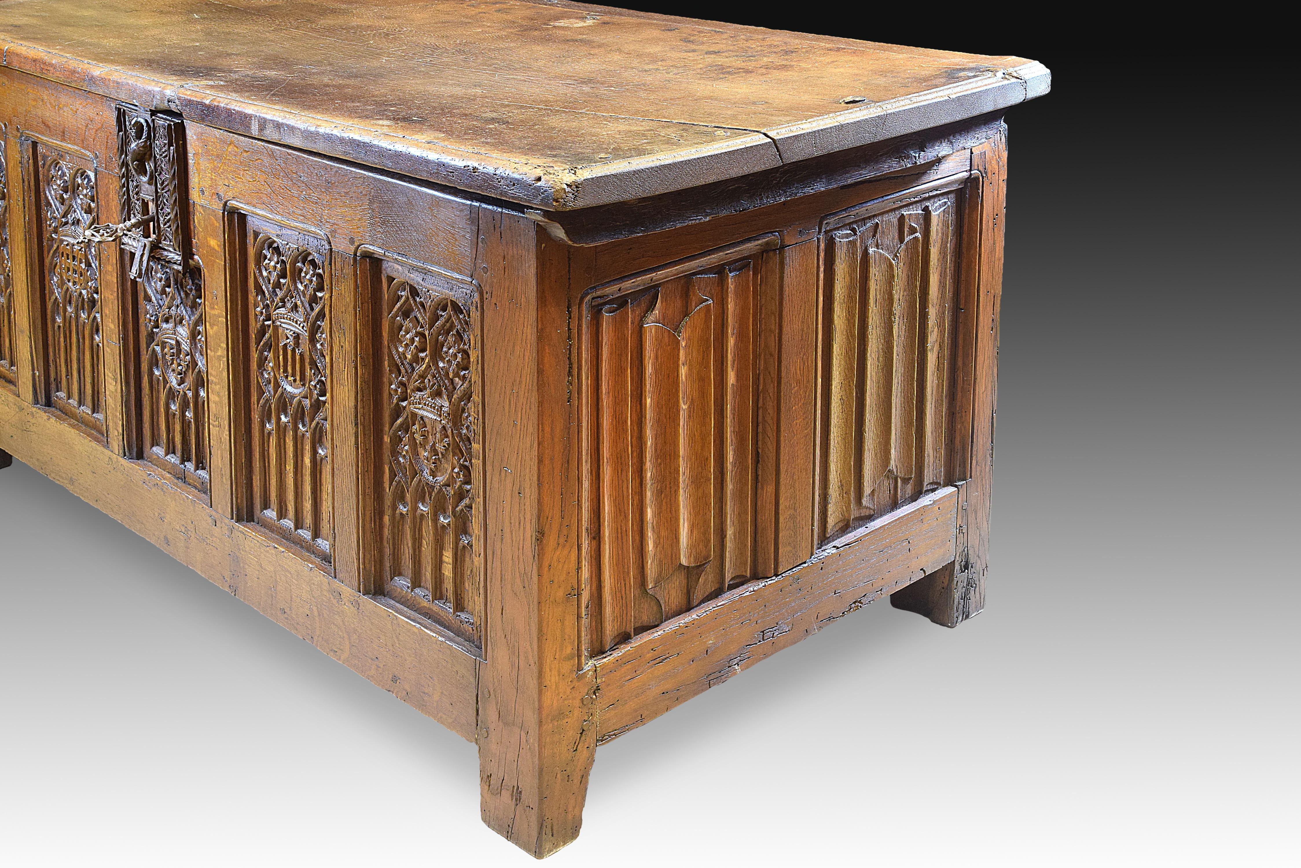 Rectangular chest with flat top and square quadrangular legs, decorated on the fronts with different elements framed in rectangles with curved beveled corners. On the sides, there is a size called 