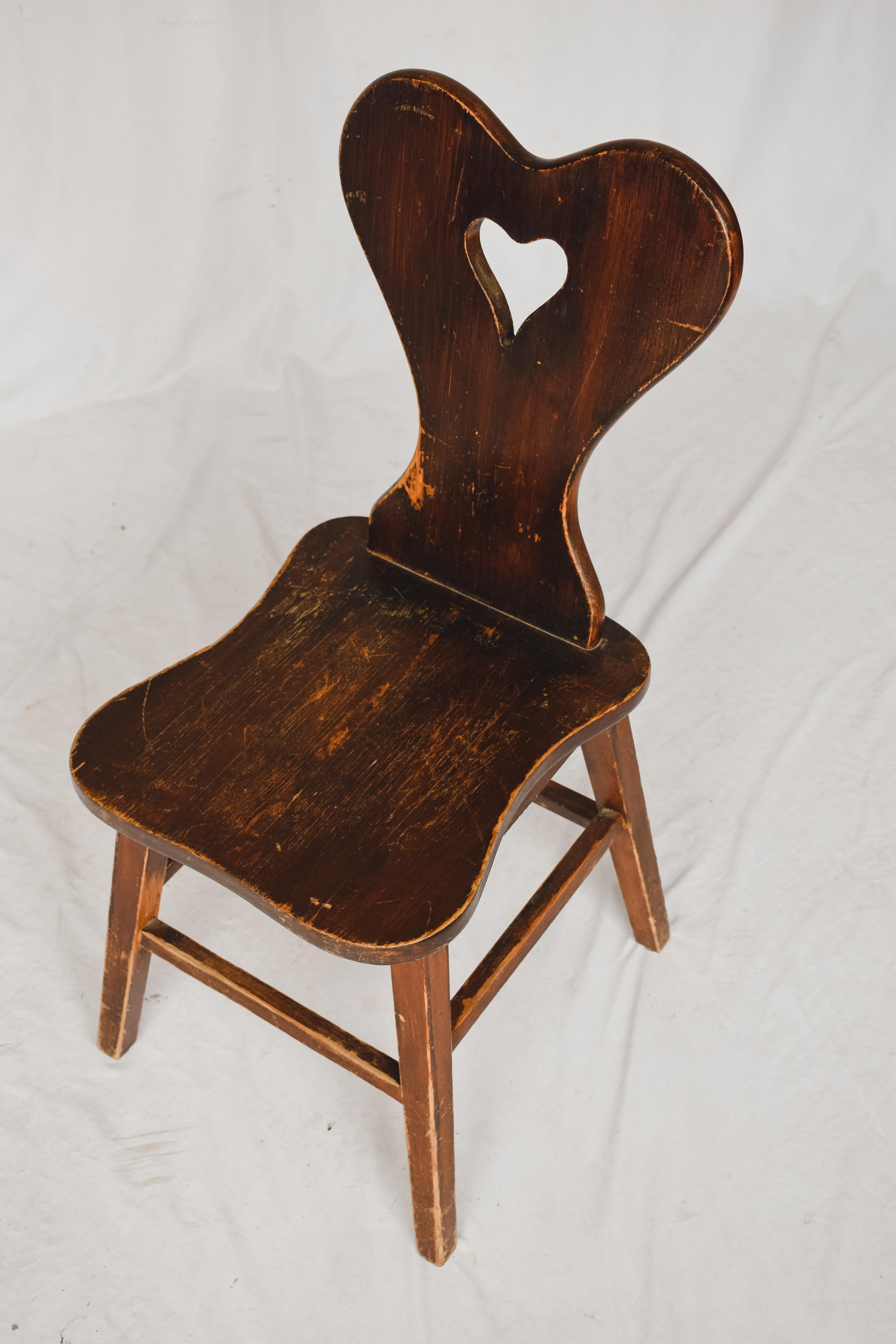 Rustic and simple these Wooden chairs with an open heart carved in the back are the perfect companion to any desk or entry table. Purchased in Europe these wooden chairs almost mirror the milking chairs found in all over the Netherlands. This chair
