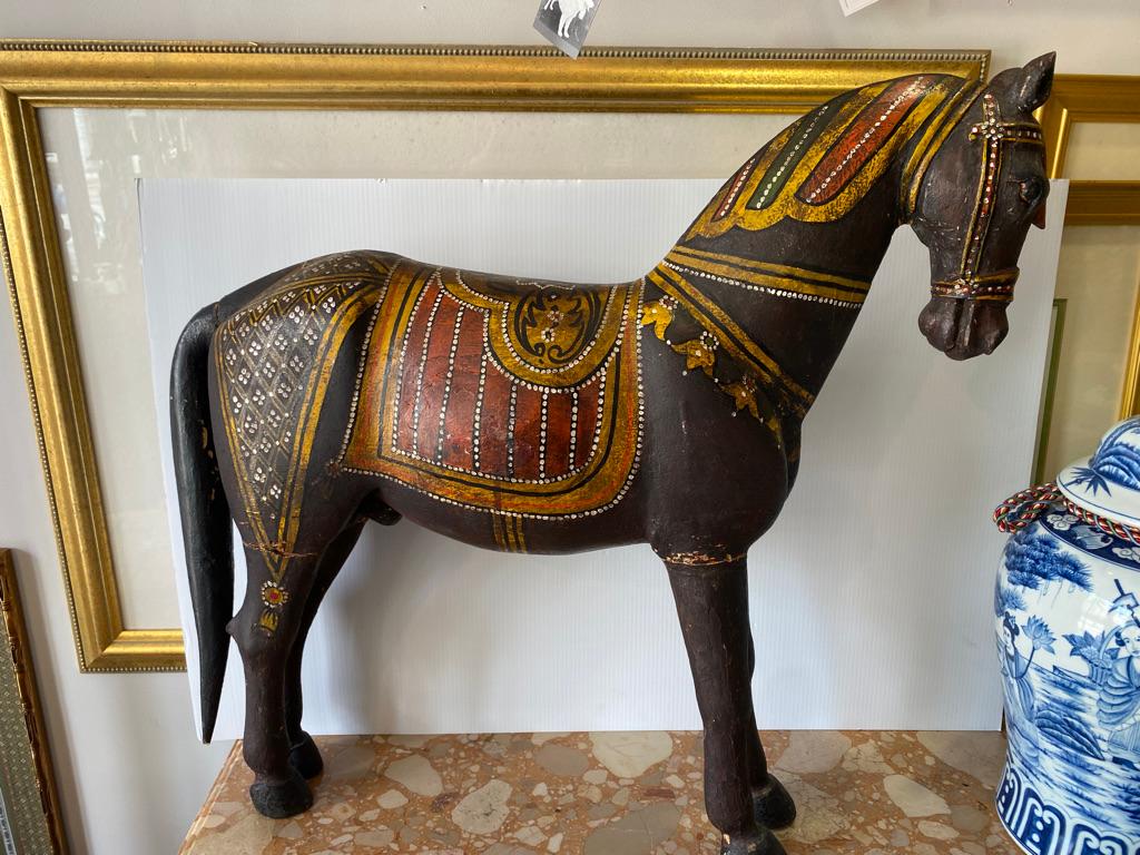 Hand carved wooden horse painted black with lots of detail.
