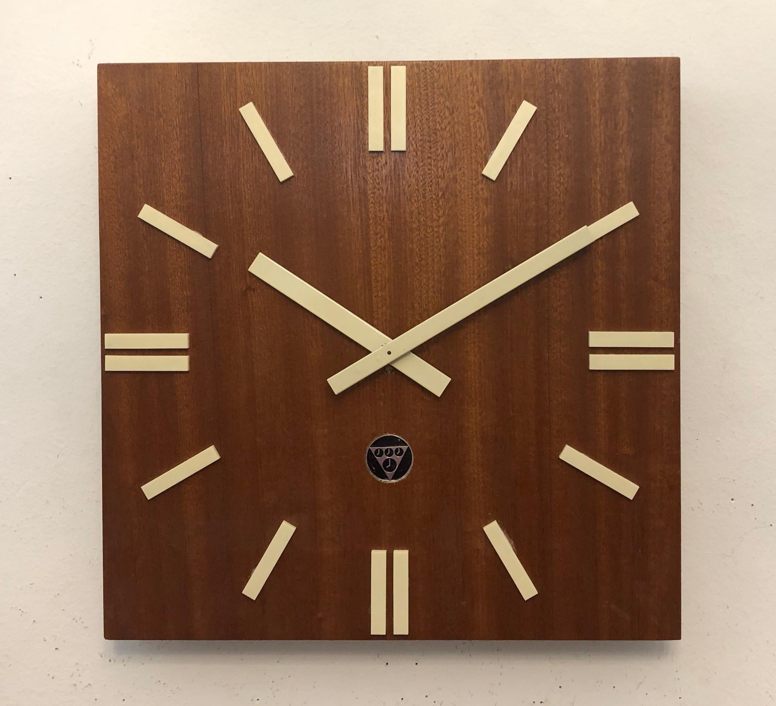 Industrial wall clock Pragotron. Frame made of a softwood and mahogany veneer. Formerly a slave clock, it is now fitted with a modern quartz movement with an AA-battery.