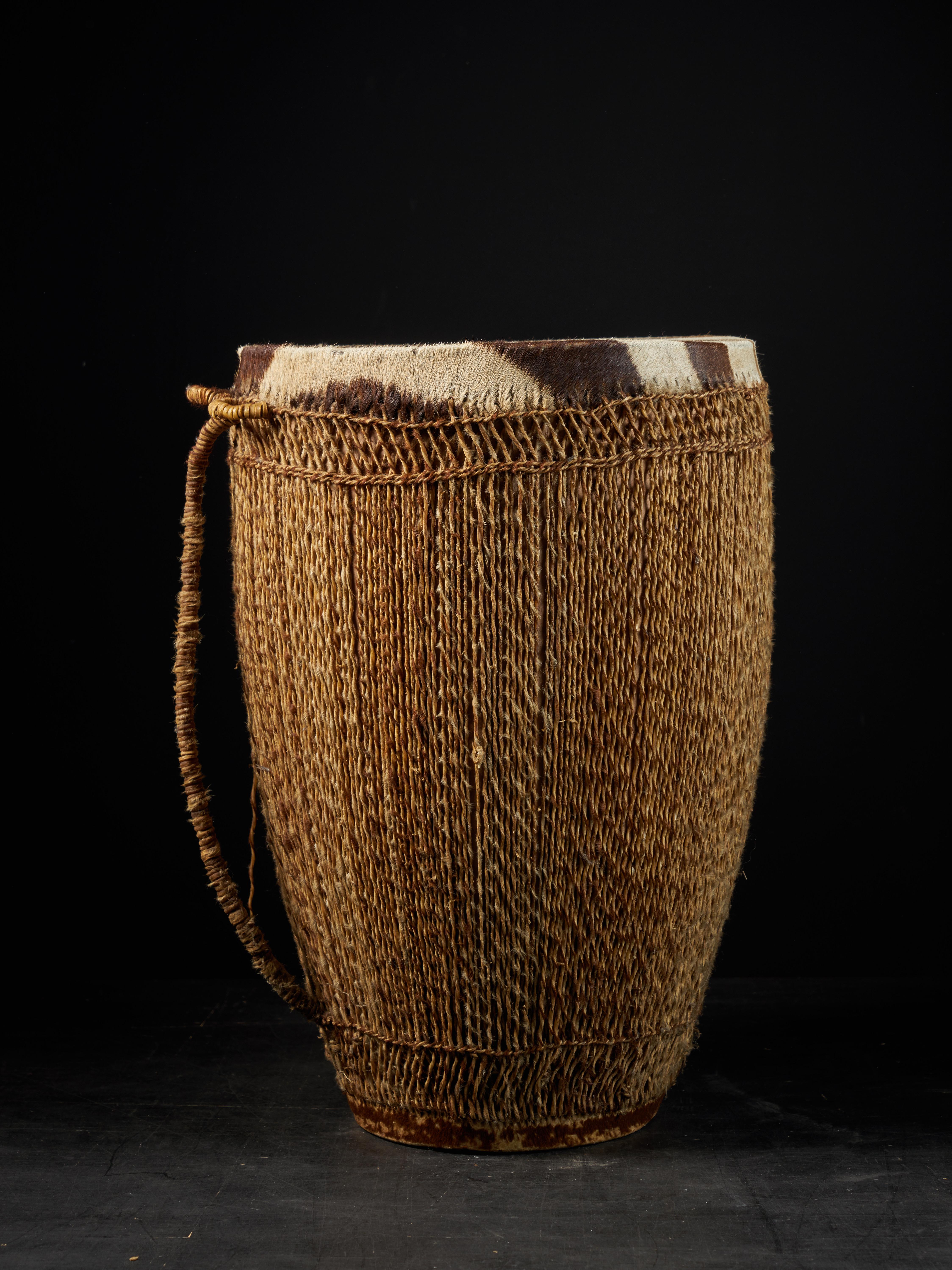 This Ingoma drum is covered with a membrane of animal skin. The drum is cylindrical in form and the top broader than the bottom it originates from the Tutsi People, an ethic group living within Rwanda and Burundi. The Tutsi formed the traditional