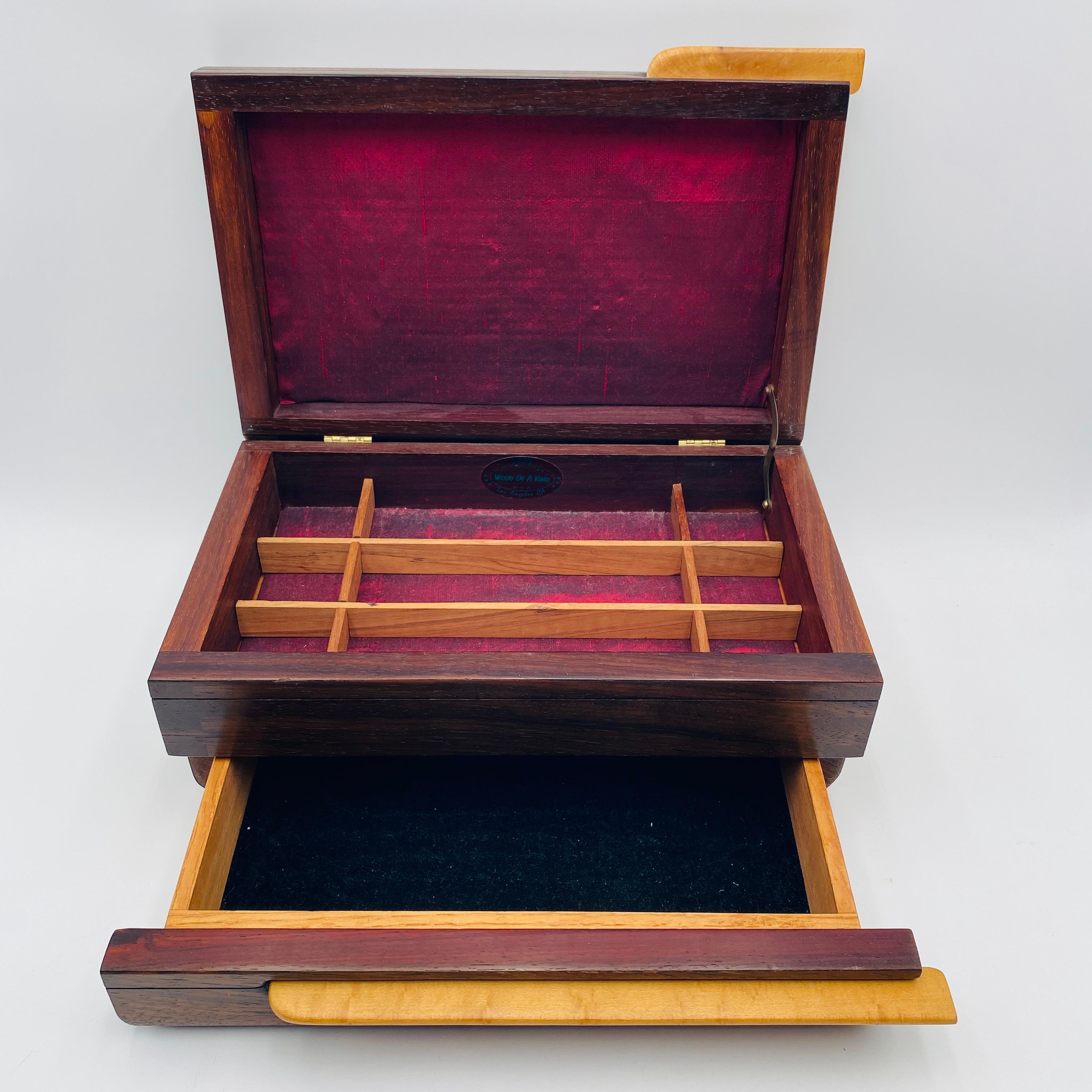 Voici une magnifique boîte à bijoux en bois, fabriquée à la main avec de l'érable et du noyer. Il est doté d'un plateau élévateur à neuf compartiments et d'un tiroir qui s'ouvre facilement. L'ensemble de la boîte présente de magnifiques détails.